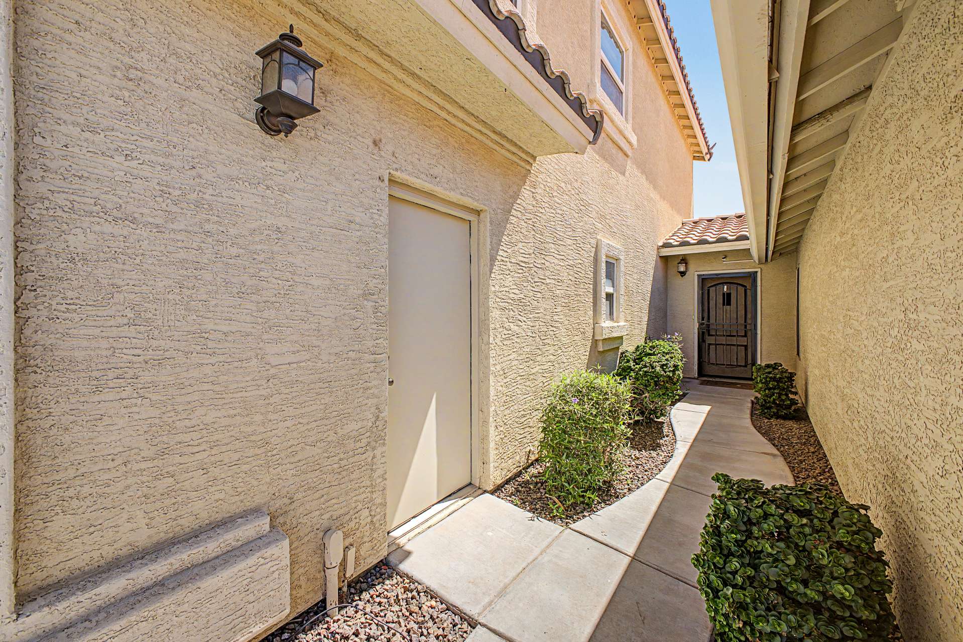 19 of 47. A private covered walkway welcomes you home with attractive landscaping, clean architectural lines, and easy access to the front entry, creating a warm and inviting arrival experience.
