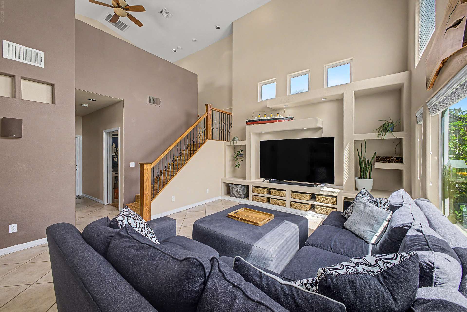 21 of 47. Designed for both entertaining and everyday comfort, the great room showcases dramatic ceilings, custom entertainment built-ins, oversized windows, and an open layout filled with natural light.