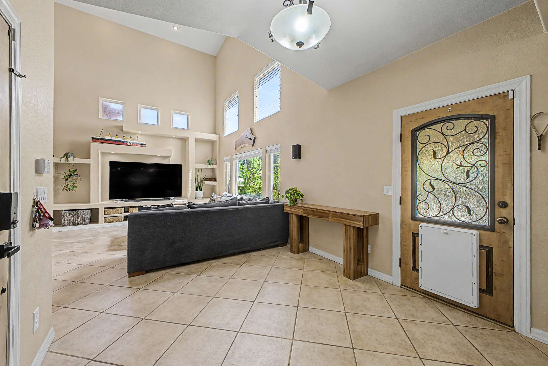 24 of 47. Welcome guests through a beautiful custom entry door into a bright foyer featuring soaring ceilings, neutral finishes, and an open layout that highlights the home's spacious and inviting design.