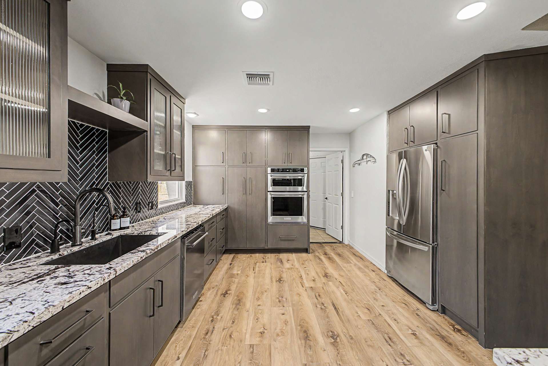 27 of 47. This impressive kitchen features custom alder cabinetry, granite countertops, stainless steel appliances, double ovens, induction cooking, and extensive storage designed for today's modern lifestyle.