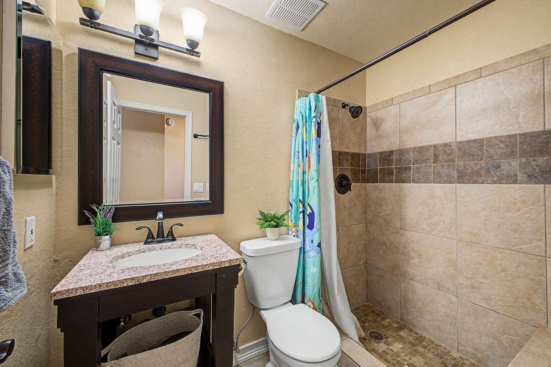 36 of 47. Enjoy an updated guest bathroom with a granite vanity, framed mirror, modern lighting, and a tiled walk-in shower designed with attractive finishes and everyday functionality.