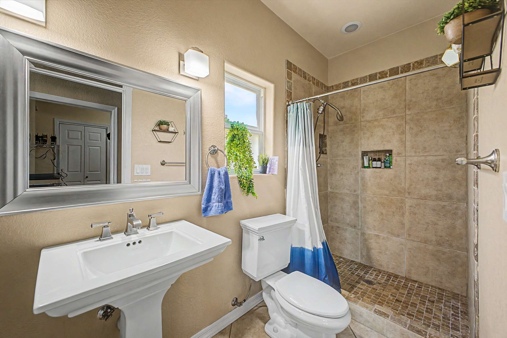 38 of 47. This well-appointed bathroom includes a pedestal sink, updated fixtures, tiled walk-in shower, and neutral finishes that complement the home's modern updates throughout.
