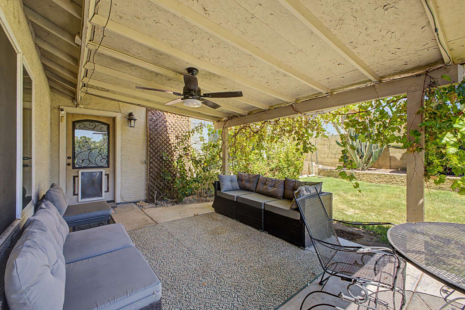 44 of 47. Relax beneath the covered patio complete with a ceiling fan and comfortable seating area overlooking the landscaped backyard. An inviting extension of the living space in this Glendale rental home.
