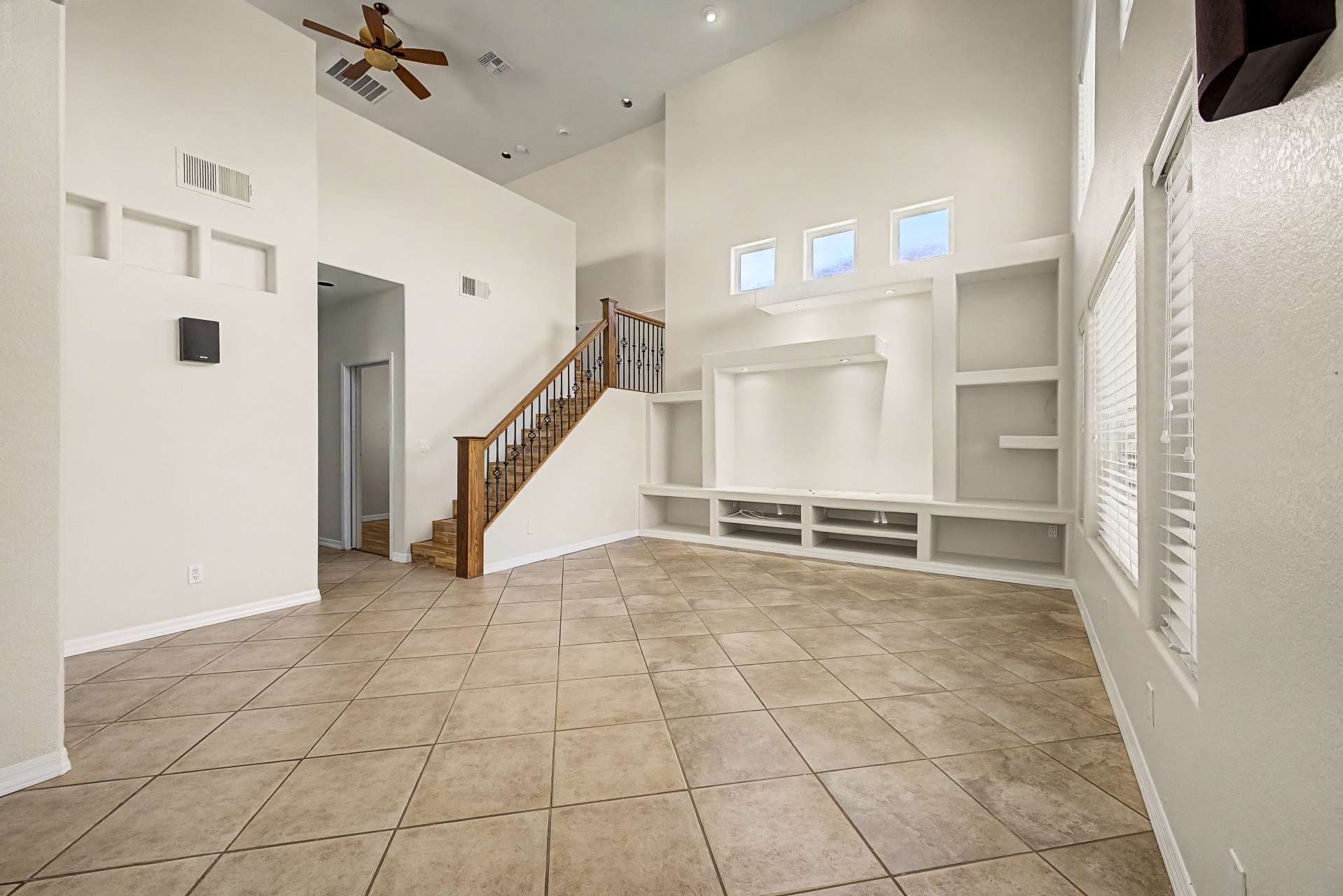 6 of 47. Oversized windows and soaring ceilings flood the great room with natural light, while the custom entertainment center creates an inviting focal point for comfortable everyday living.