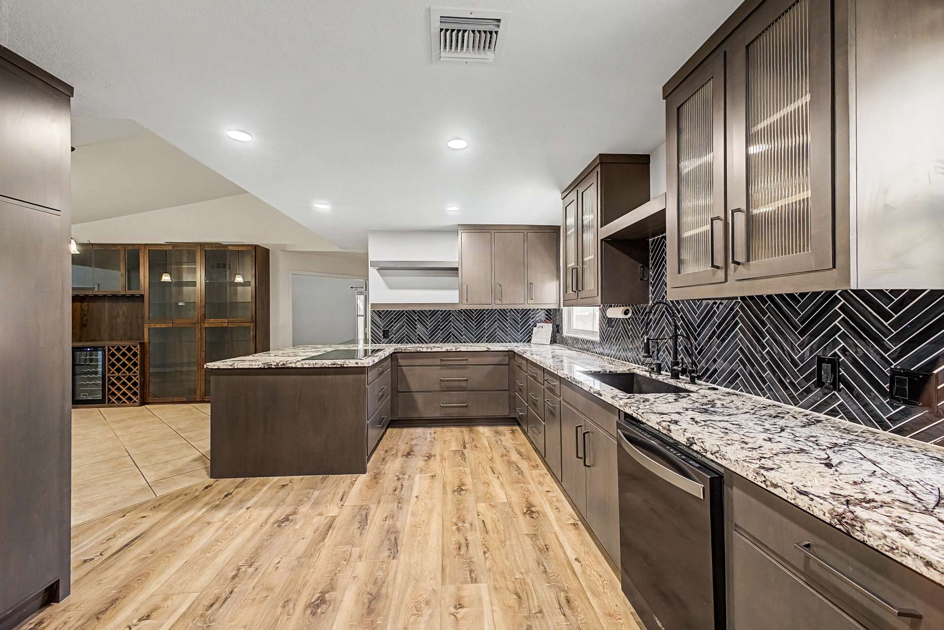 10 of 47. This beautifully renovated kitchen combines custom cabinetry, granite counters, designer backsplash, and generous prep space to create the perfect setting for cooking and entertaining.