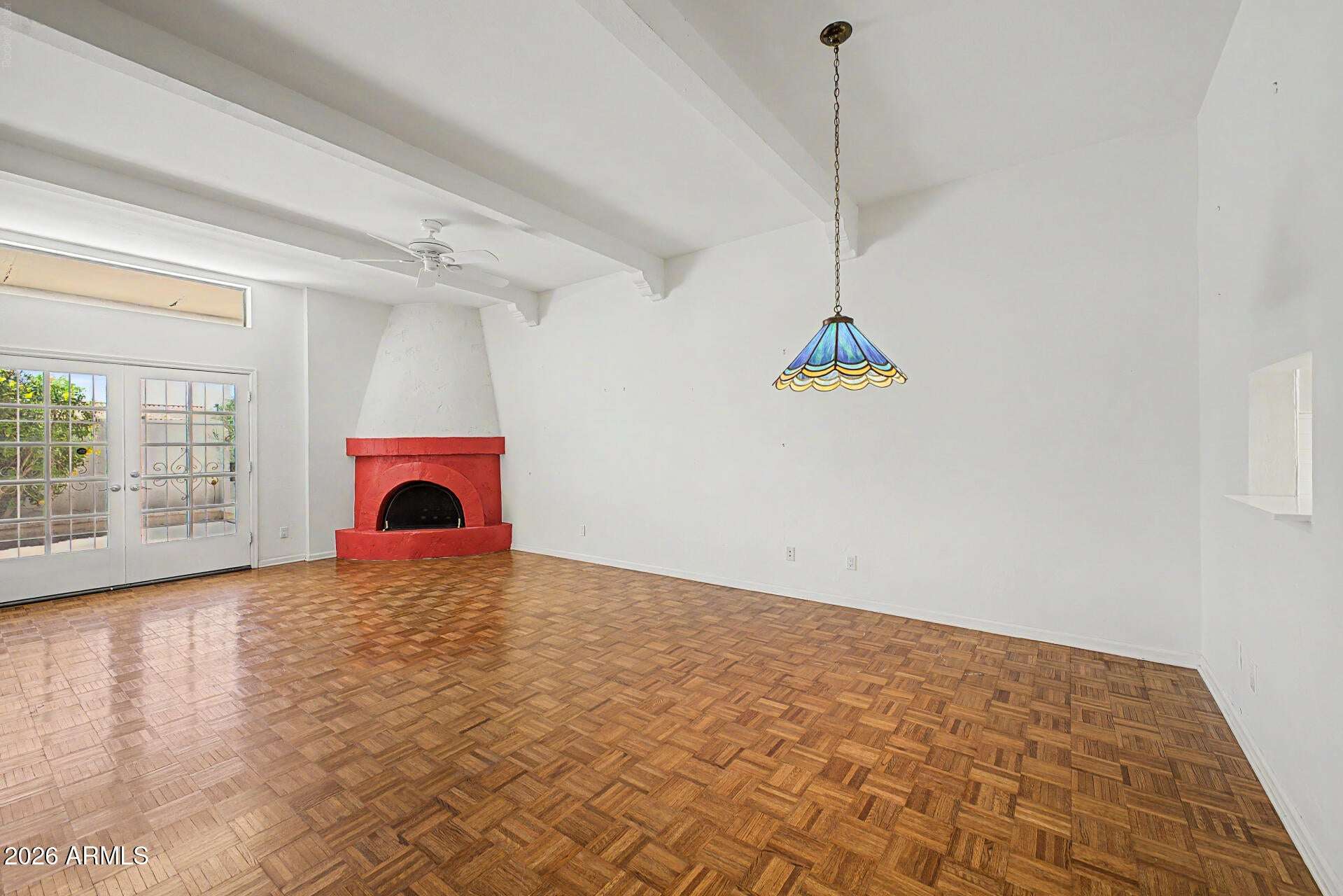 8 of 30. Large great room featuring soaring ceilings, exposed beams, parquet flooring, and a dramatic fireplace. The open floor plan creates an ideal gathering space for family and guests.