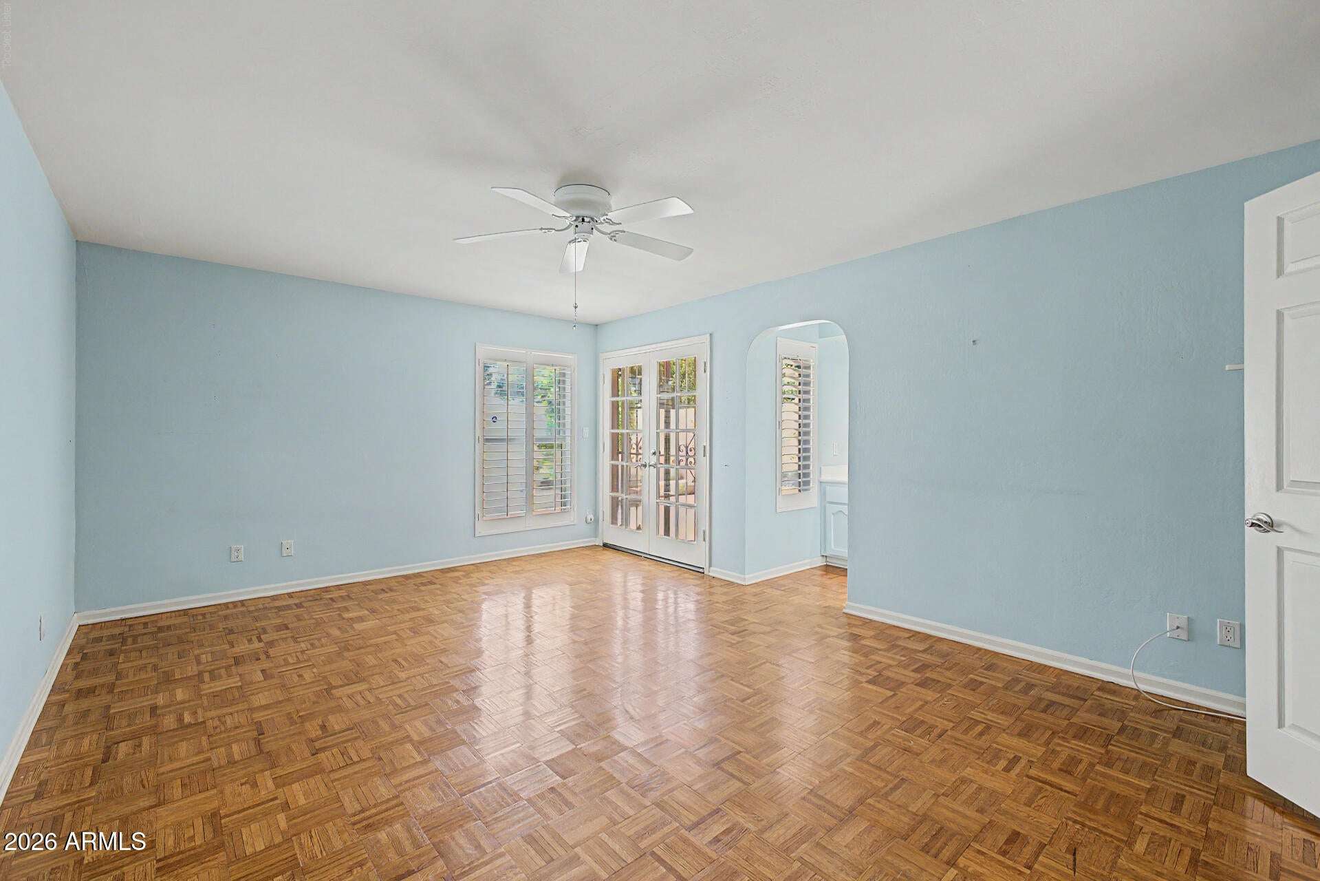13 of 30. Bright primary bedroom with ample floor space, elegant French doors, and natural light. The room's flexible layout easily accommodates a variety of bedroom furniture arrangements.