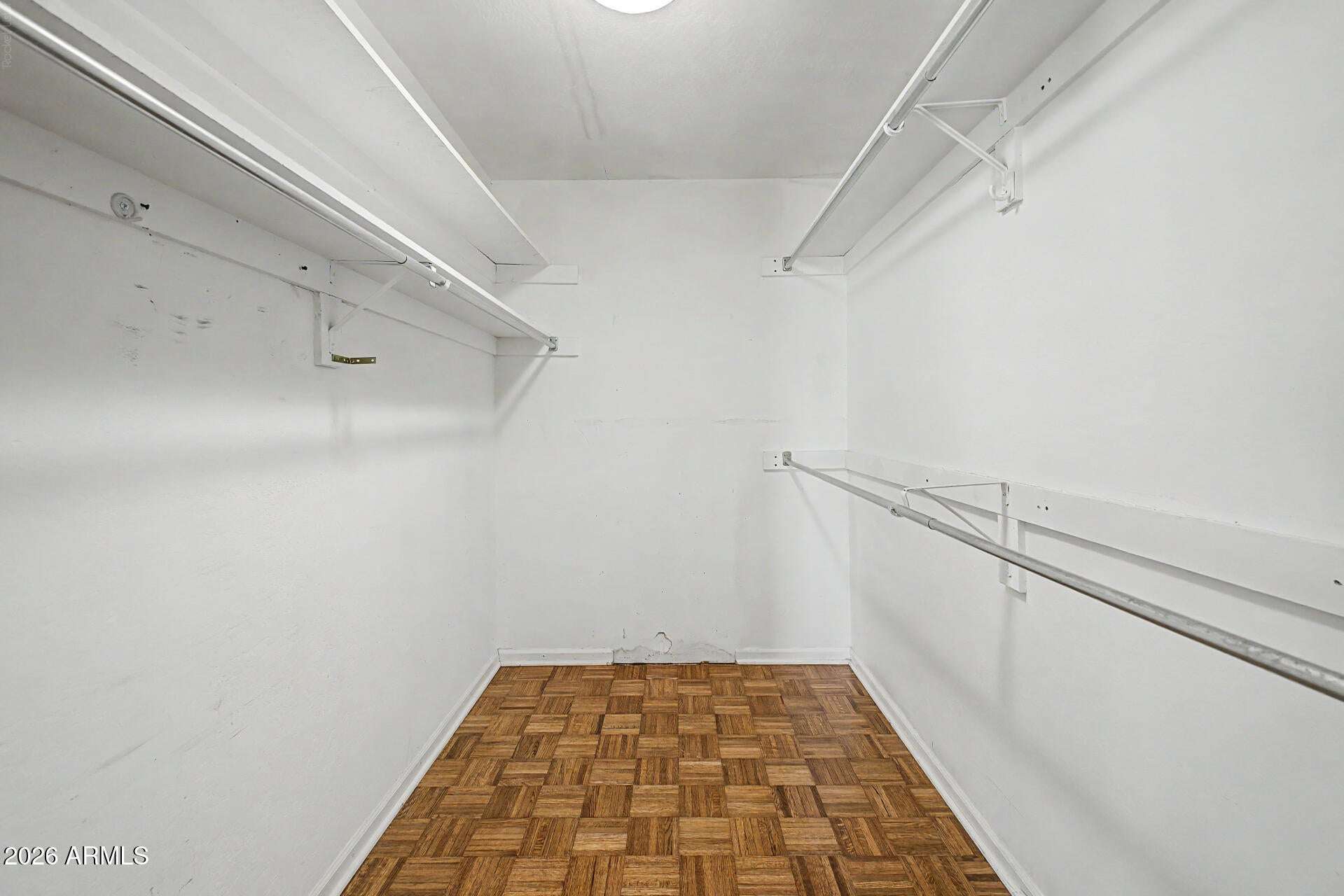 16 of 30. Roomy walk-in closet featuring extensive hanging space and practical storage solutions. A valuable feature that helps maximize organization within the primary suite.