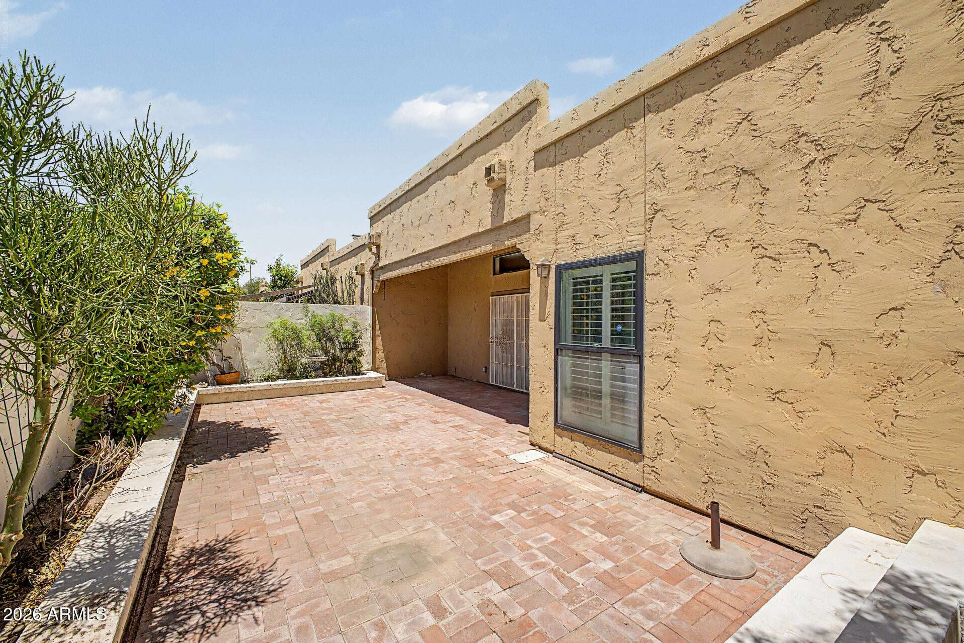 26 of 30. Expansive patio area offering privacy, mature greenery, and flexible outdoor living options. Perfect for dining, entertaining, gardening, or relaxing in the Scottsdale sunshine.