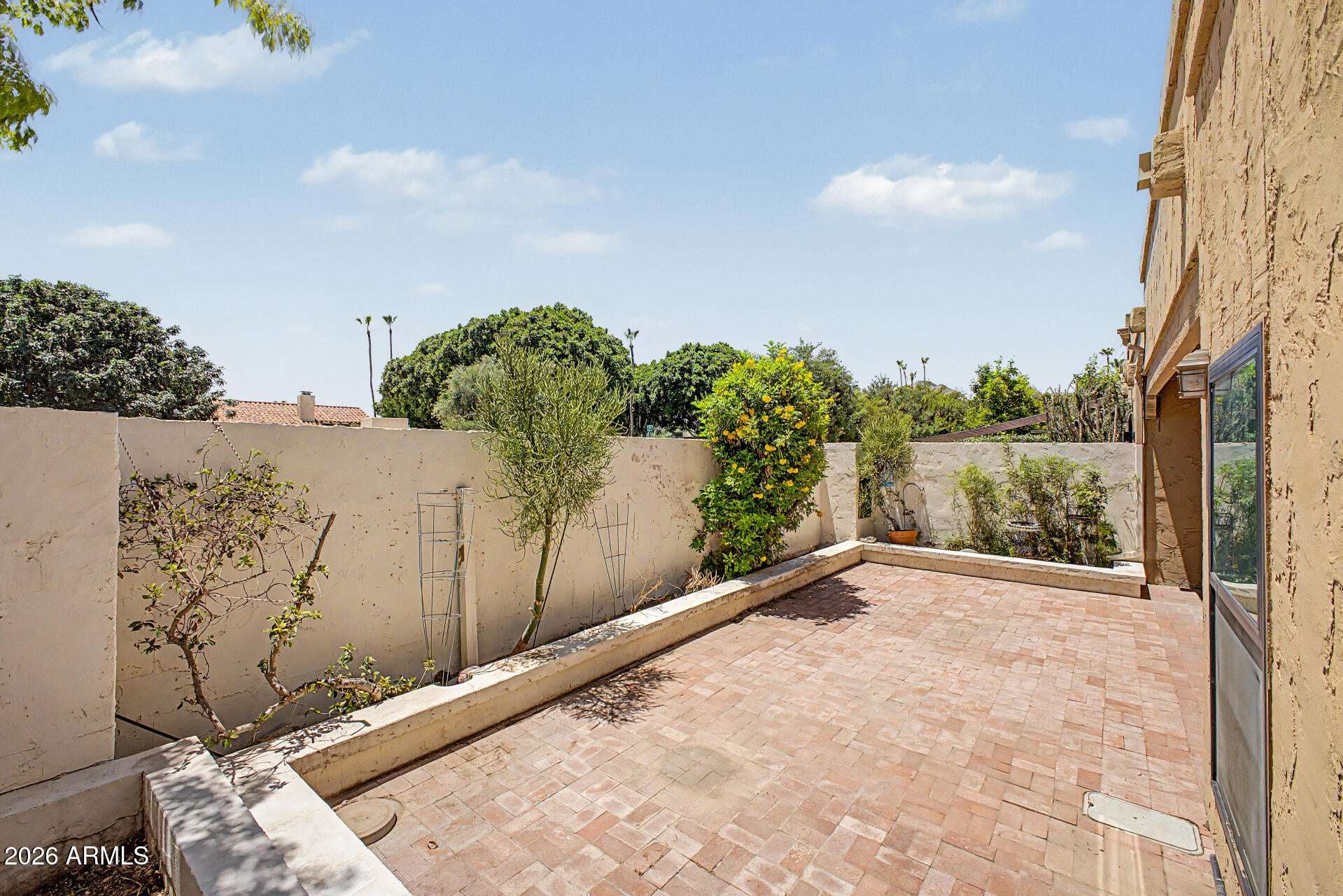 27 of 30. Large paver courtyard framed by mature landscaping and privacy walls. This inviting outdoor setting provides an excellent extension of the home's living and entertaining space.