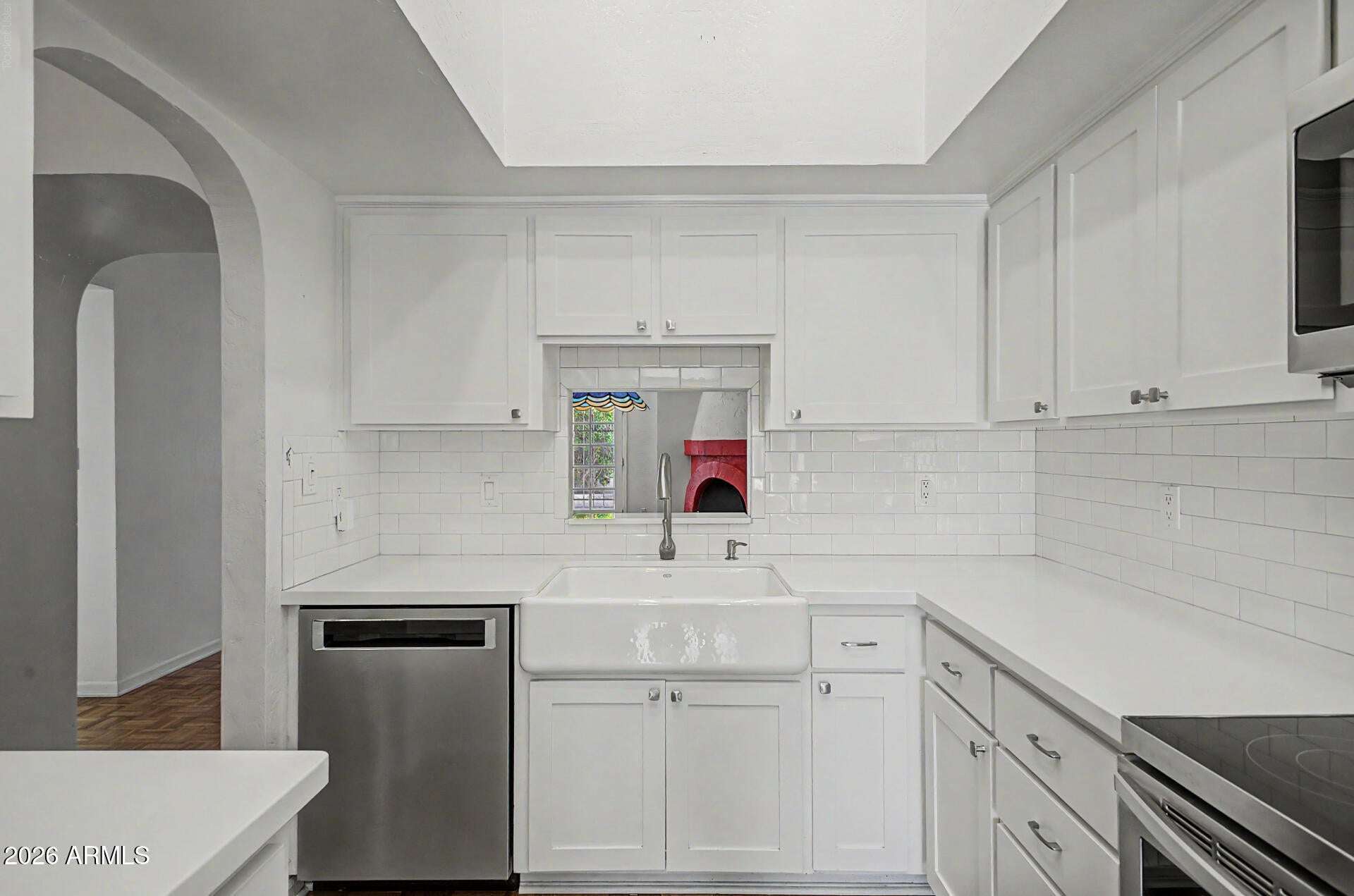 5 of 30. Stylish kitchen featuring a farmhouse sink, modern finishes, extensive cabinetry, and stainless steel appliances. Natural light and clean design elements make this space both beautiful and practical.