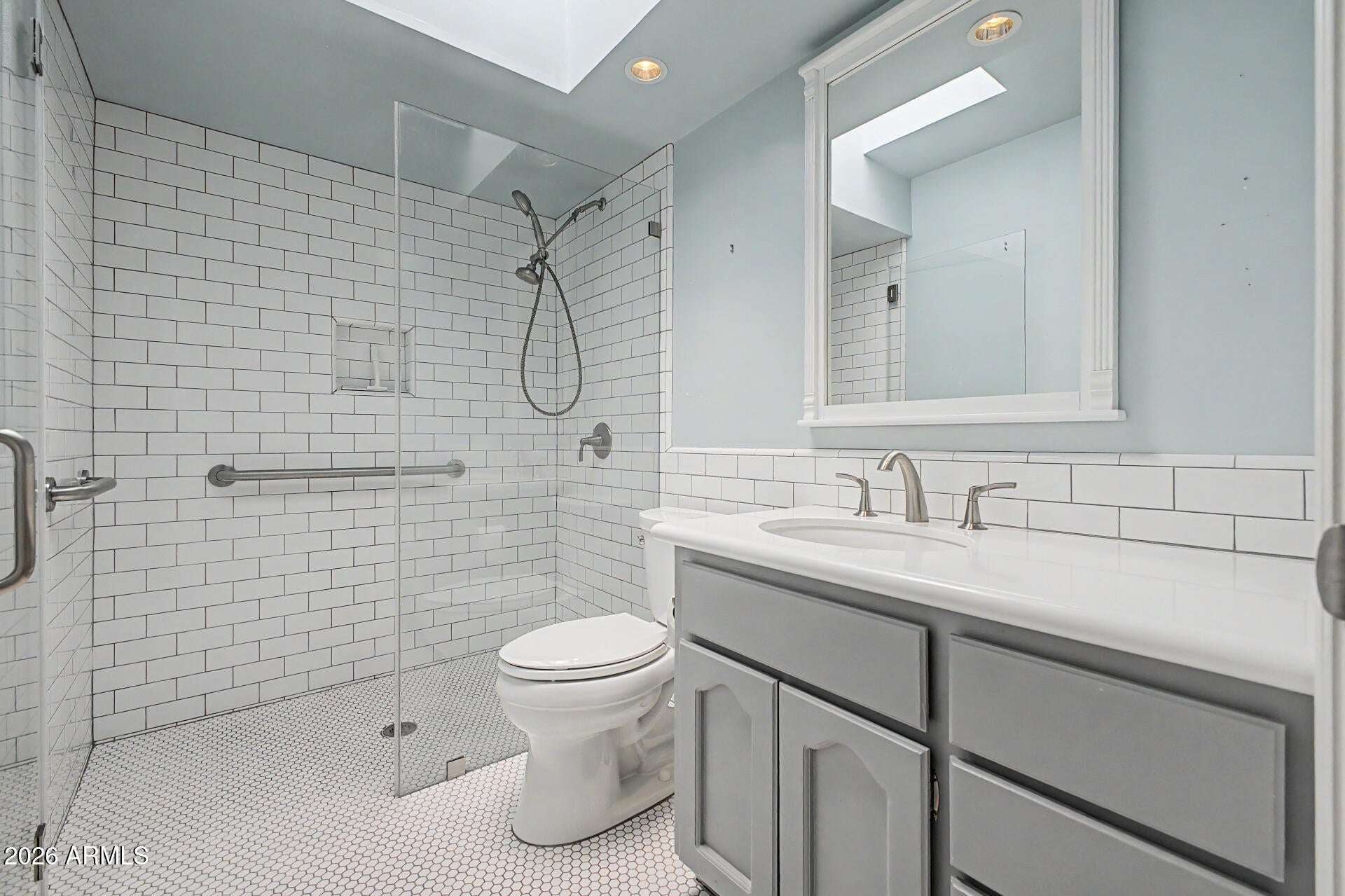 19 of 30. Updated bathroom featuring a sleek walk-in shower with subway tile walls, glass enclosure, and modern finishes. The stylish design creates a clean and refreshed look.