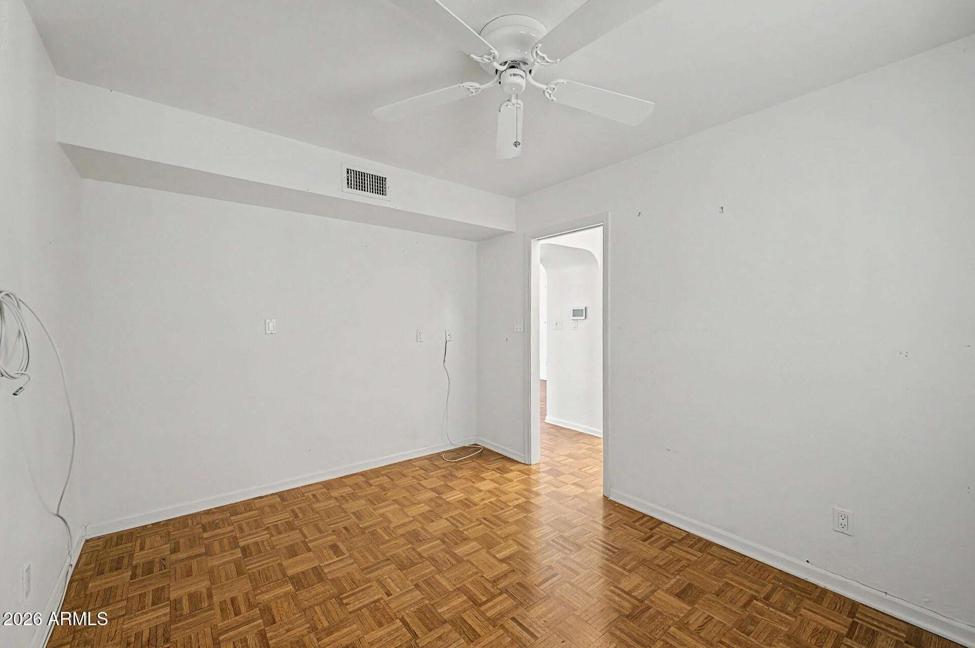 21 of 30. Flexible living space featuring parquet flooring, ceiling fan, and a neutral color palette. Ideal for a home office, craft room, guest quarters, or additional living area.
