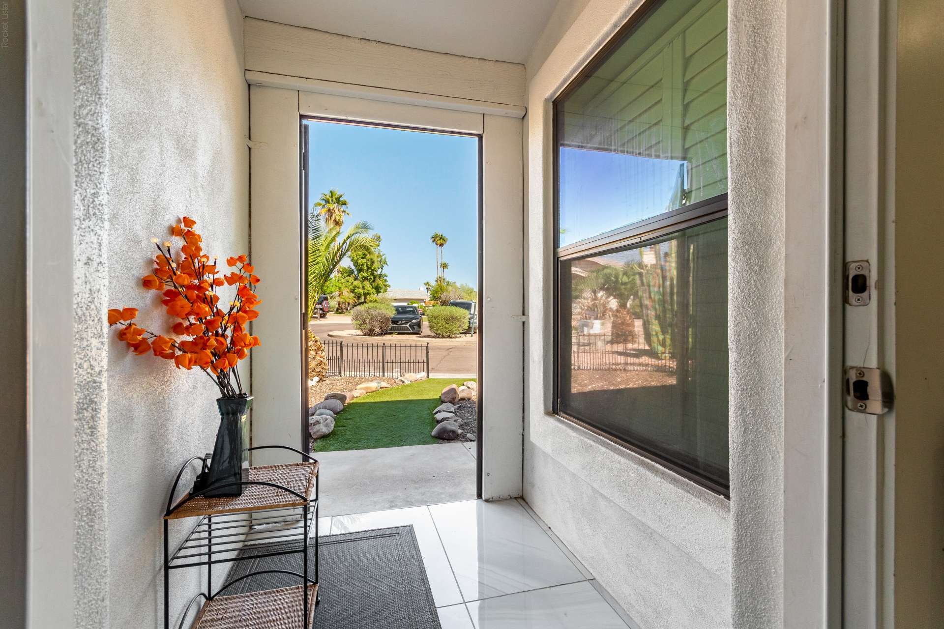 3 of 34. The covered entry welcomes guests with a bright foyer and an inviting transition into the home's spacious interior. Natural light enhances this warm and functional entryway.
