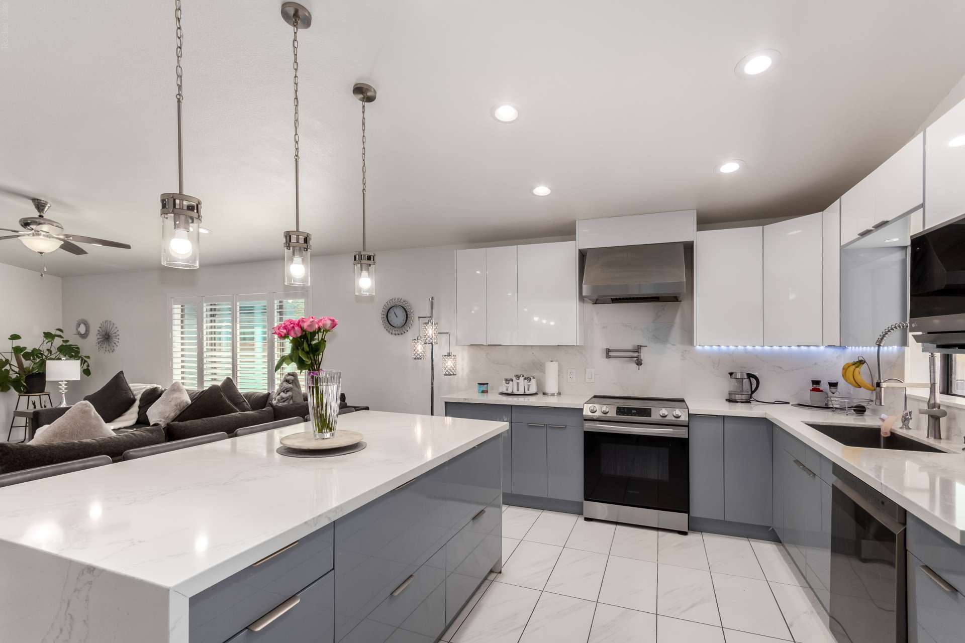 4 of 34. The updated kitchen features an impressive quartz island, contemporary cabinetry, stainless steel appliances, and elegant lighting. Designed for cooking, gathering, and entertaining with ease.