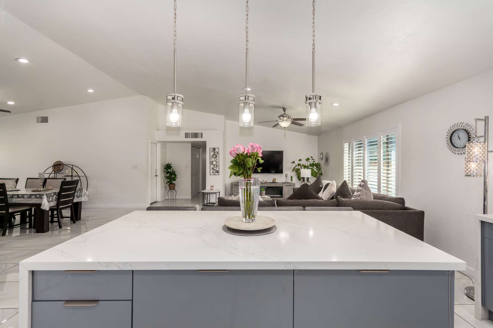 5 of 34. Overlooking the open living area, the expansive kitchen island creates a seamless space for entertaining and everyday living. Large windows bring in abundant natural light throughout the home.