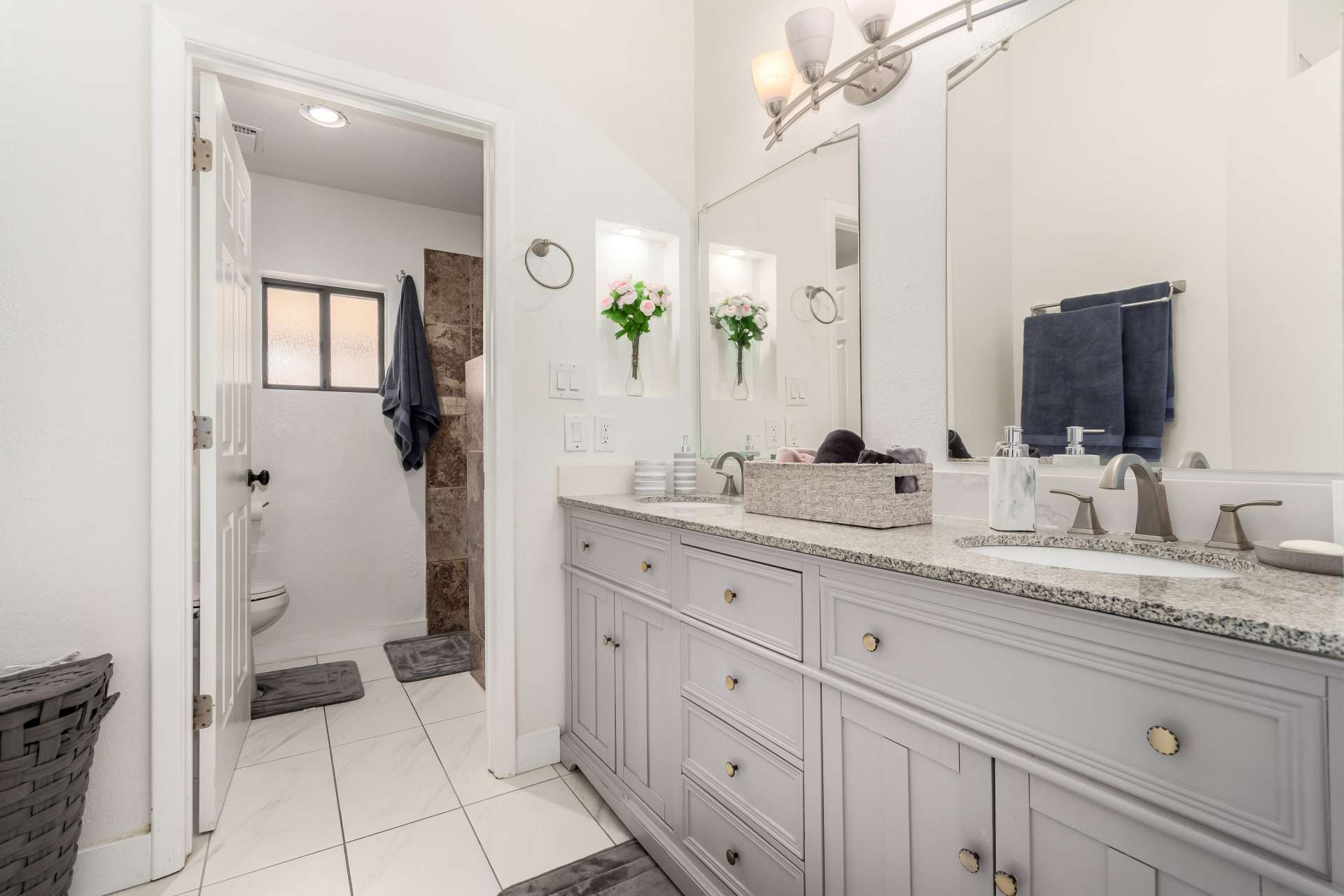 21 of 34. Elegant primary bathroom with dual sinks, granite countertops, custom cabinetry, and updated fixtures. This spacious vanity area offers both style and functionality for everyday living in Scottsdale.