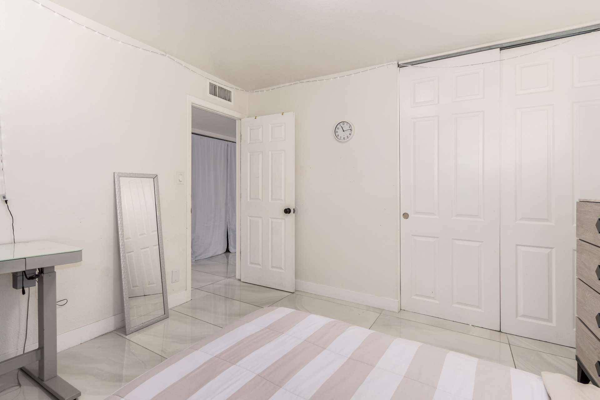 24 of 34. Additional bedroom view showcasing generous floor space, closet access, neutral finishes, and plantation shutters that enhance comfort and natural light throughout.