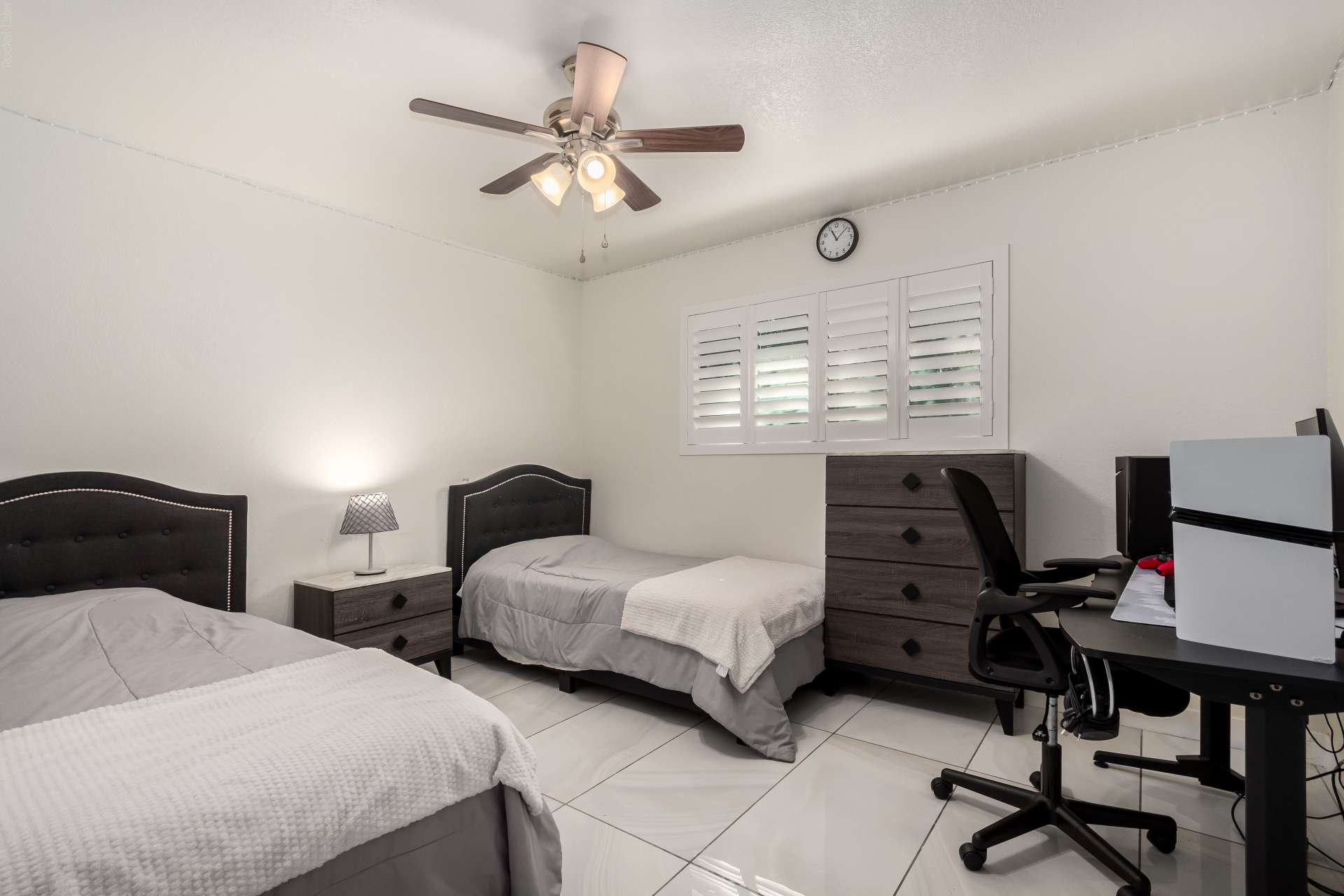 25 of 34. Spacious guest bedroom with dual sleeping areas, plantation shutters, tile flooring, and room for work or study. A practical layout suited for growing households.