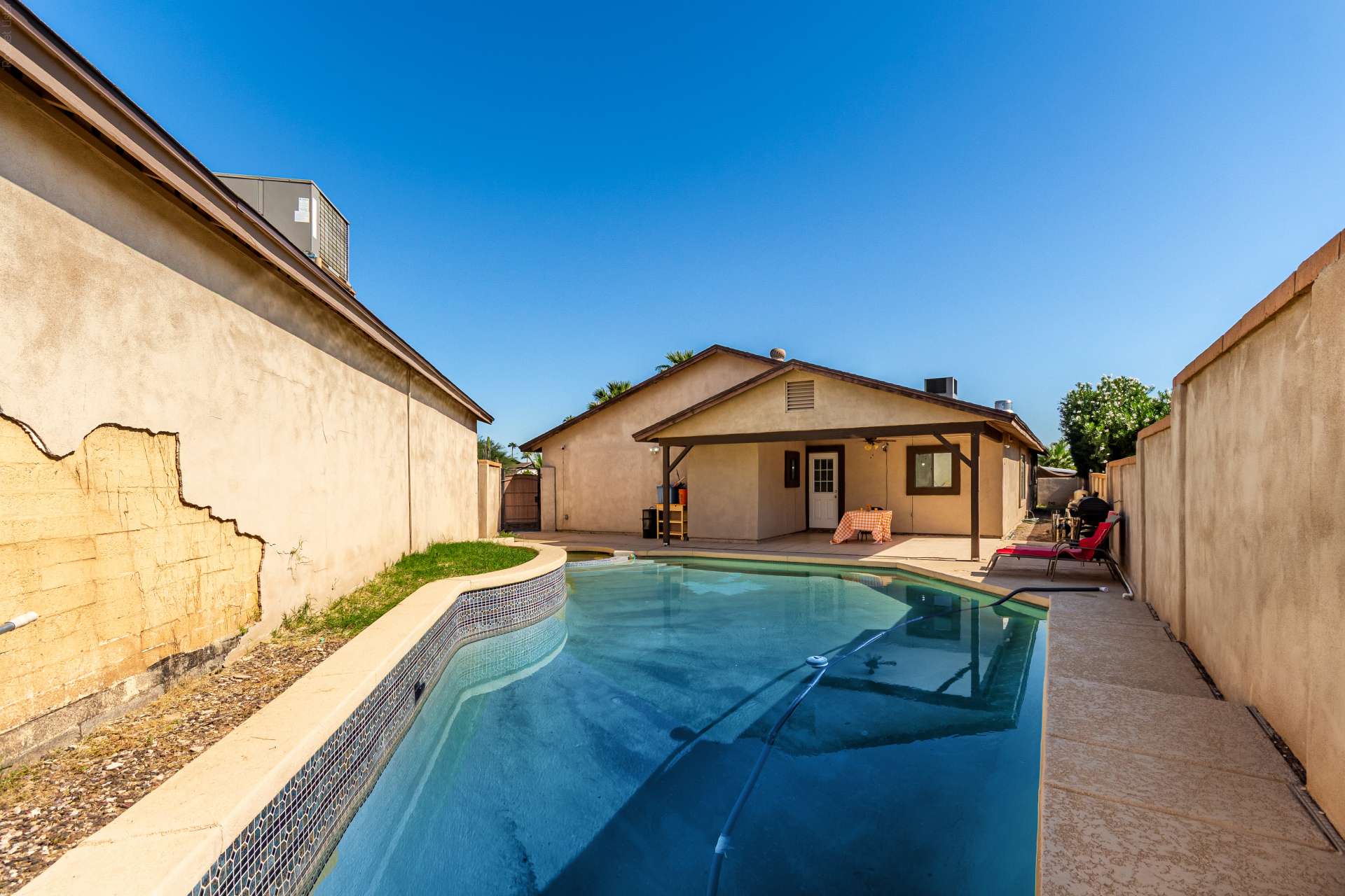 33 of 34. Expansive backyard with a refreshing pool, attached spa, covered patio, and easy-care landscaping offers plenty of space for outdoor gatherings and everyday enjoyment in Scottsdale.