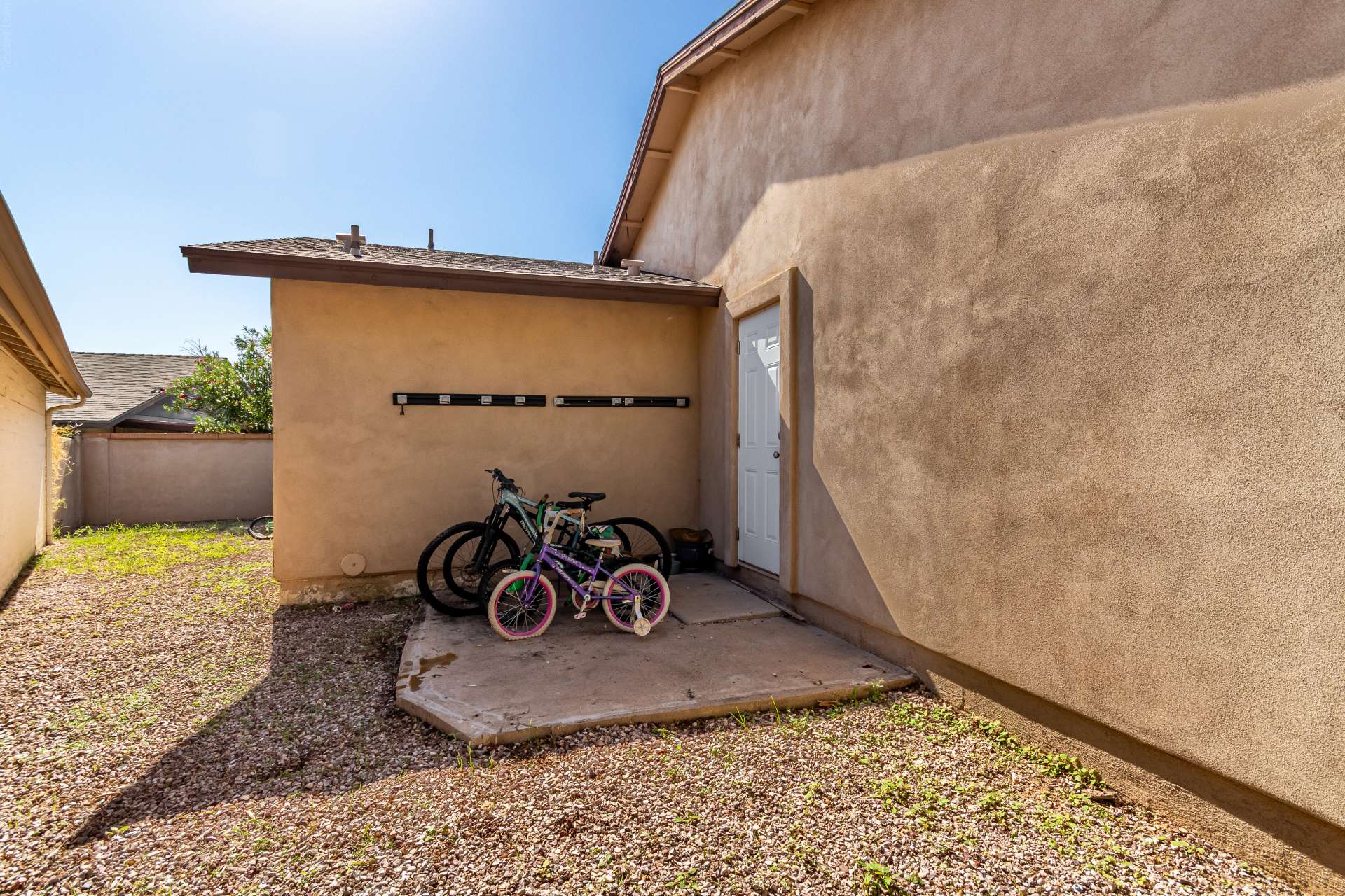 34 of 34. Convenient side yard with exterior door access, gravel ground cover, and room for storage or utility use. An added functional feature that complements the outdoor layout of this Scottsdale home.