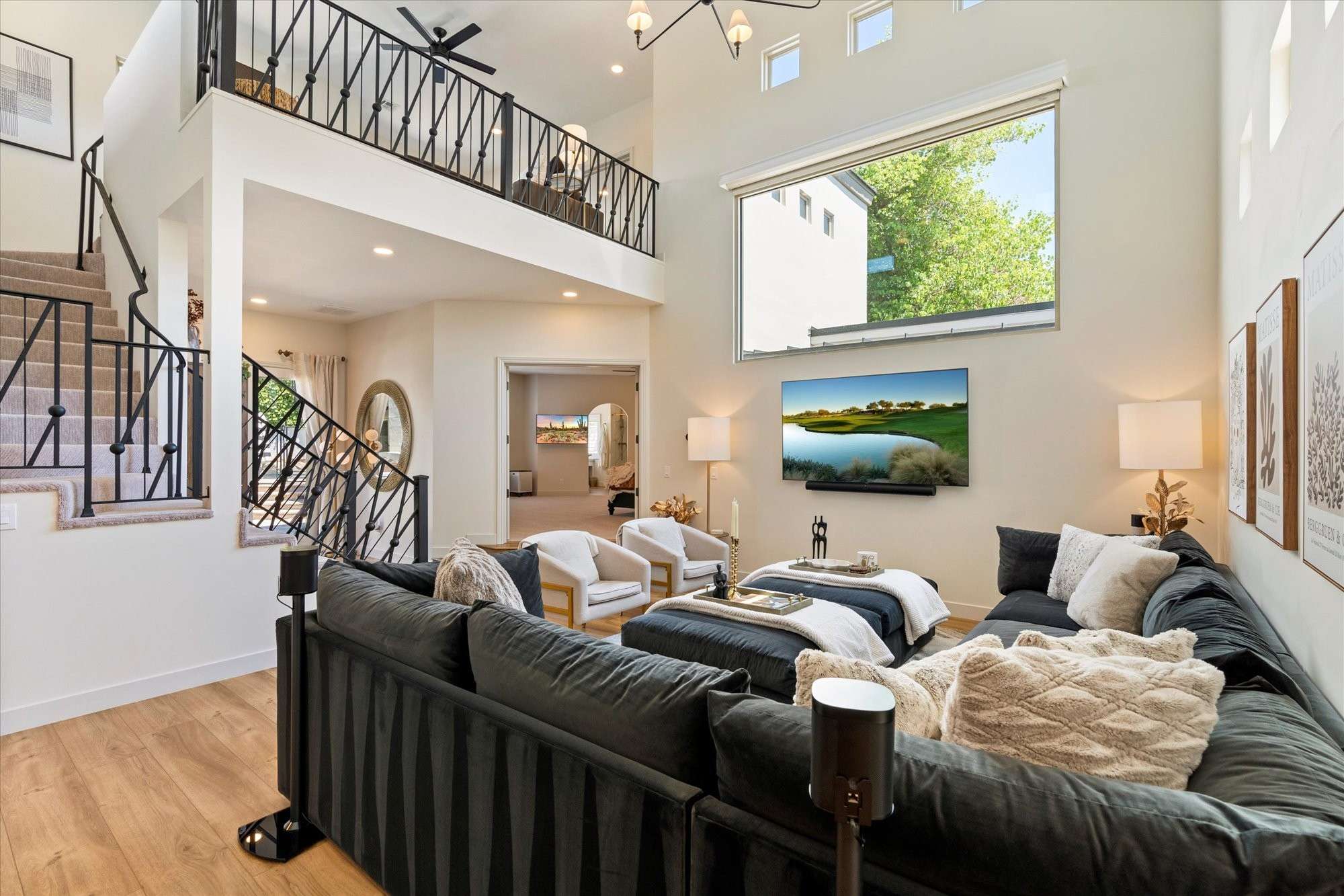 14 of 48. Stunning great room with vaulted ceilings, loft-style overlook, and modern finishes that create an open and inviting atmosphere.