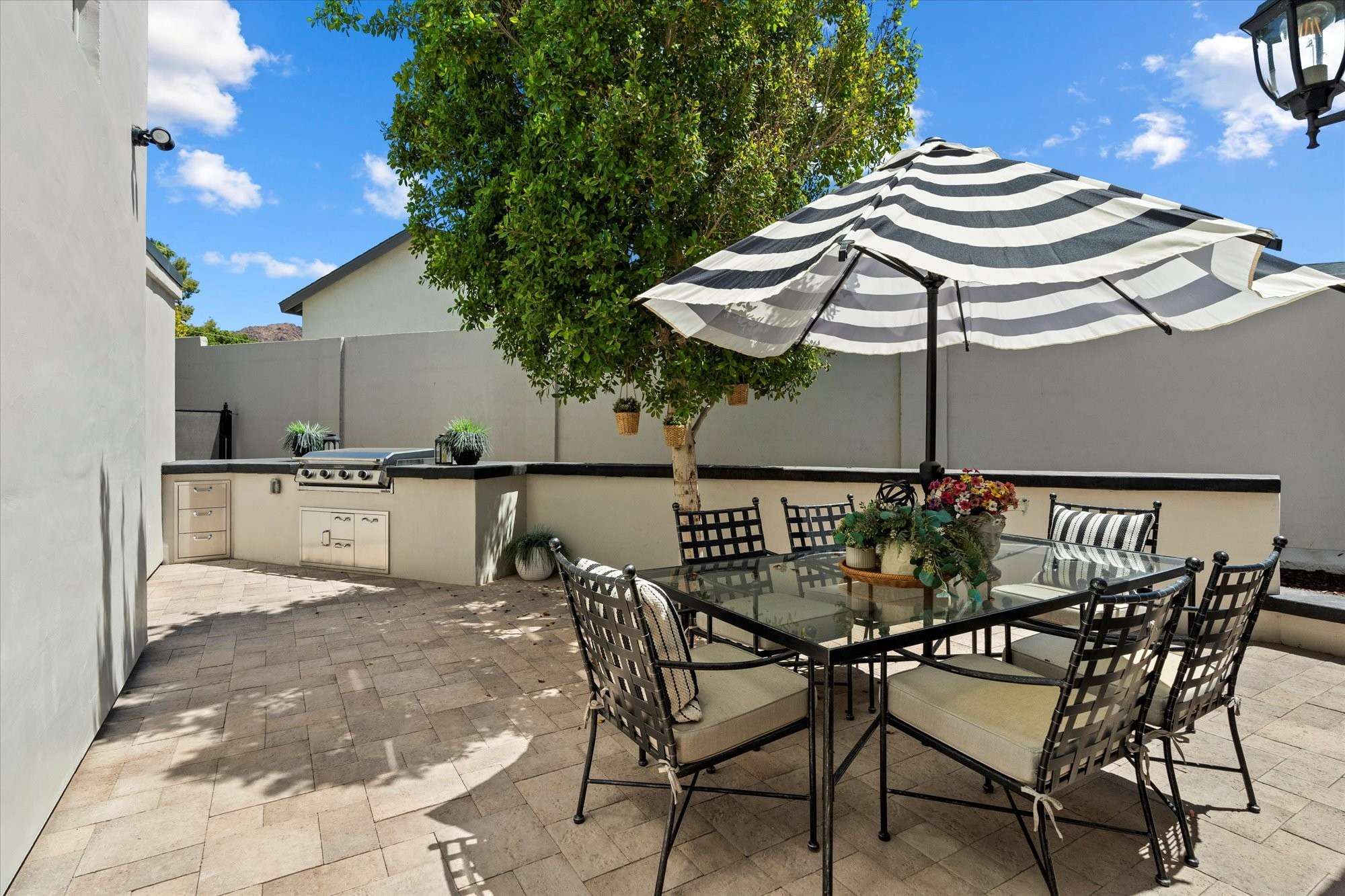 23 of 48. Inviting outdoor entertaining area with built-in BBQ, dining table, and privacy walls for year-round enjoyment in Phoenix.