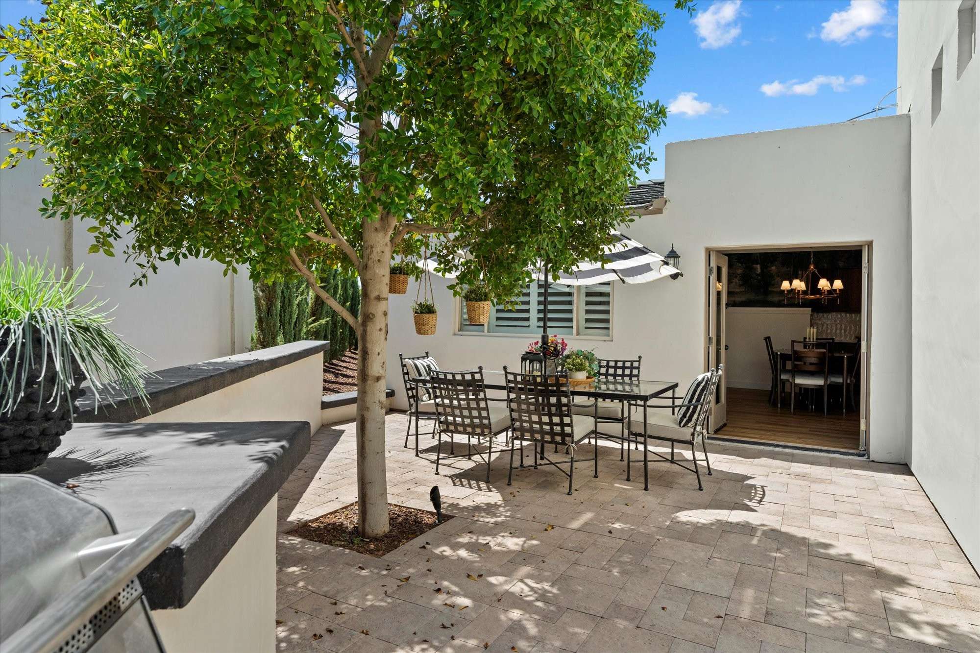24 of 48. Charming outdoor courtyard with dining area, shade tree, and easy access to interior spaces perfect for relaxed Phoenix entertaining.