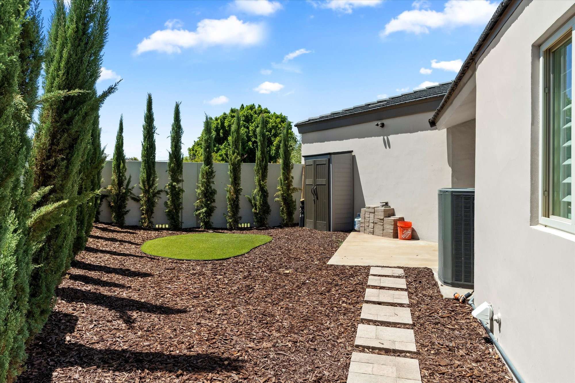 25 of 48. Private side yard with turf area, clean landscaping, and added storage offering flexible outdoor functionality and privacy.