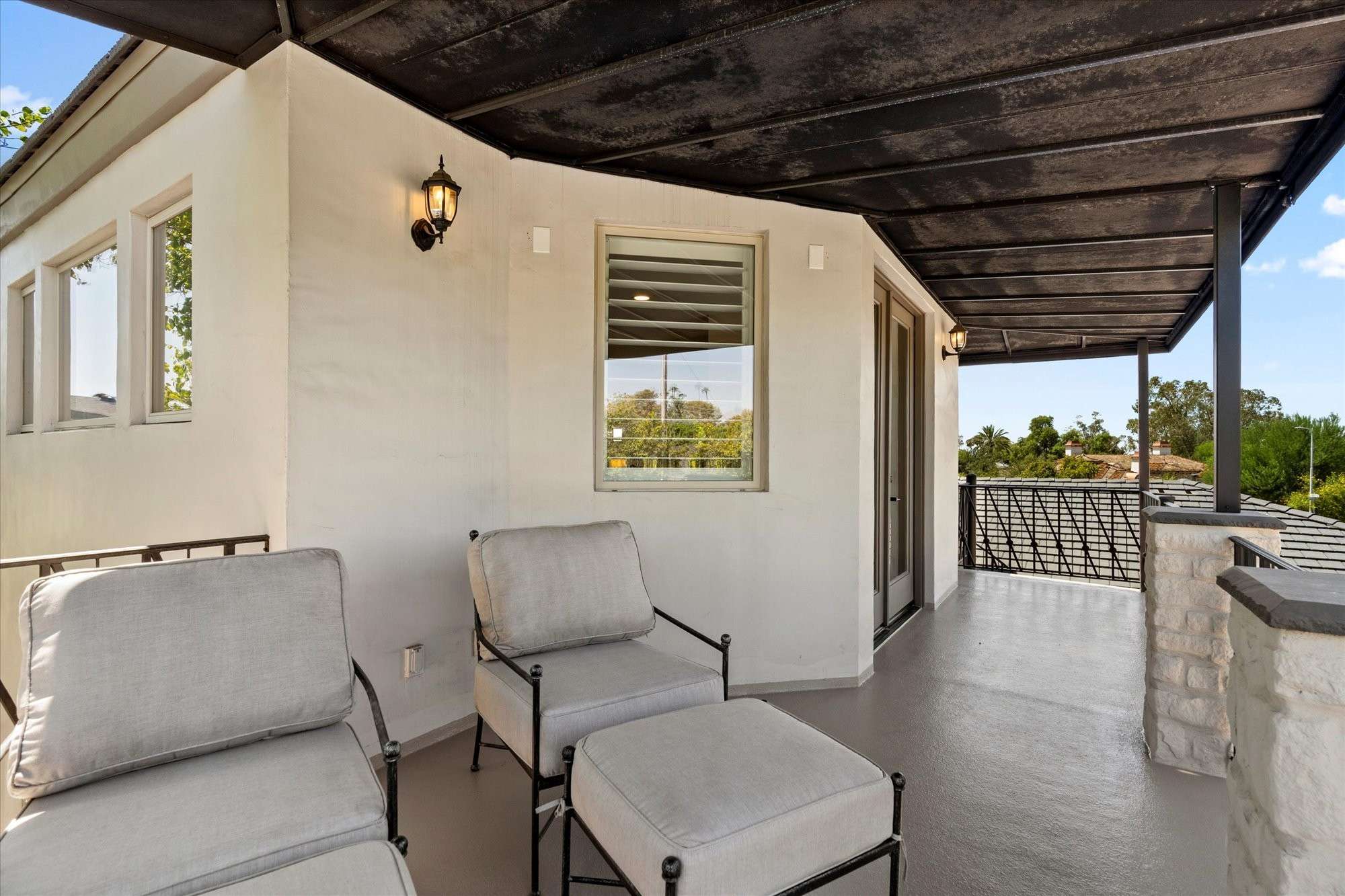 36 of 48. Upper balcony lounge with covered shade, ceiling fan, and peaceful backyard views enhancing indoor-outdoor living.