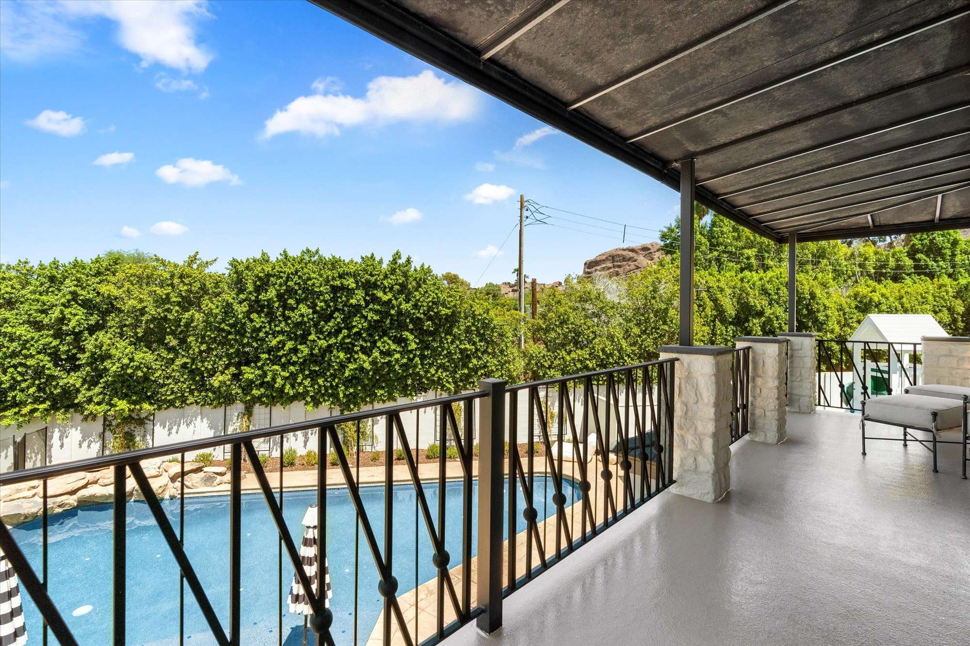 37 of 48. Quiet balcony retreat featuring seating space and open views, perfect for relaxing while overlooking the backyard and pool area.