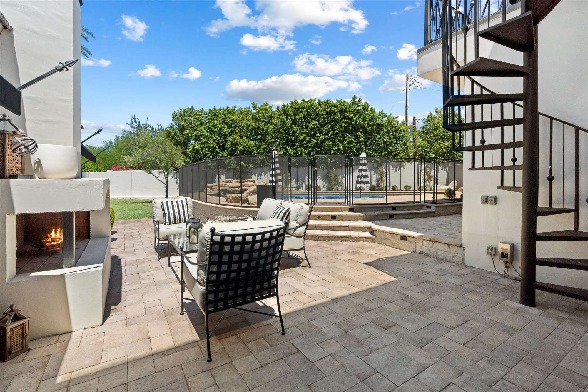 38 of 48. Charming patio with built-in fireplace, paver flooring, and intimate seating creating a cozy outdoor gathering space.