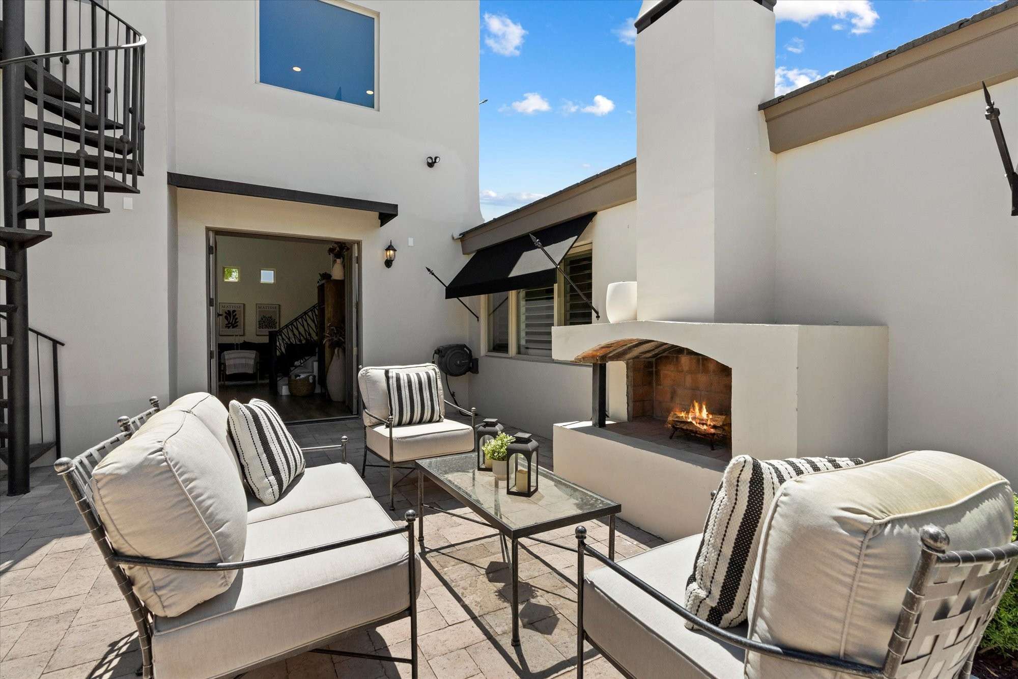 39 of 48. Outdoor entertaining area with fireplace, lounge seating, and easy access to the home s interior living spaces.