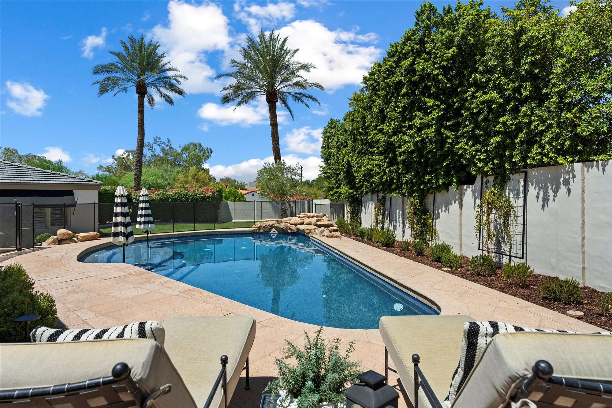 40 of 48. Inviting backyard pool surrounded by mature landscaping and ample deck space for lounging and entertaining in Phoenix.