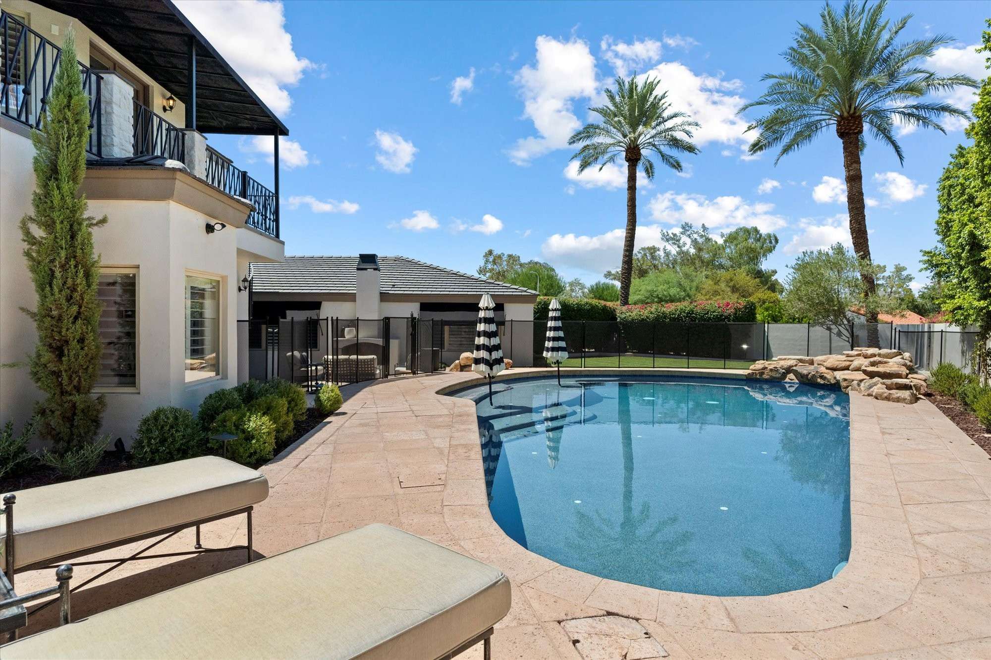 41 of 48. Resort-inspired pool featuring rock accents, clean lines, and lush greenery creating a relaxing outdoor atmosphere.