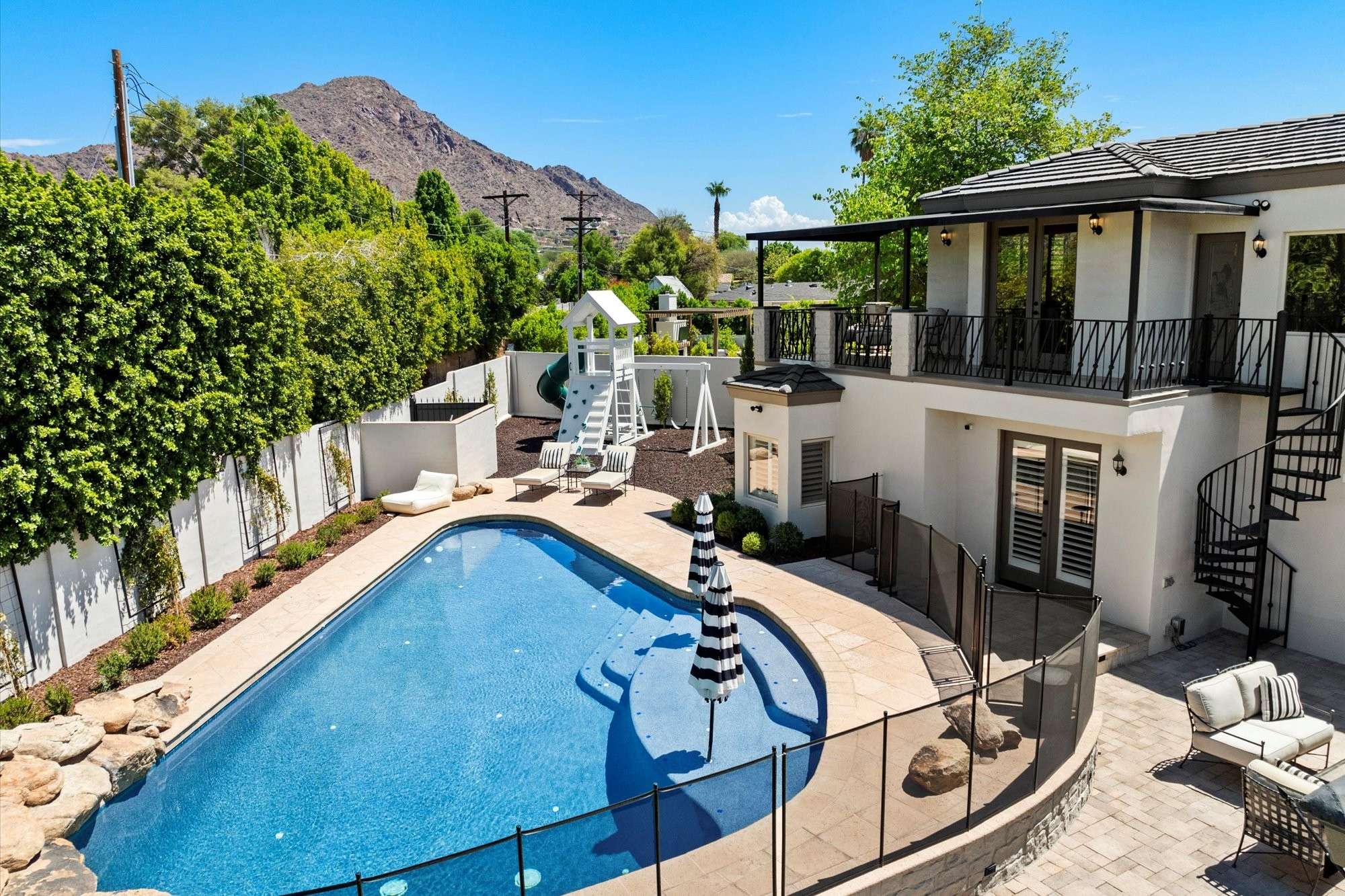 42 of 48. Fenced pool area offering safety, privacy, and open yard space, complemented by well-maintained landscaping.