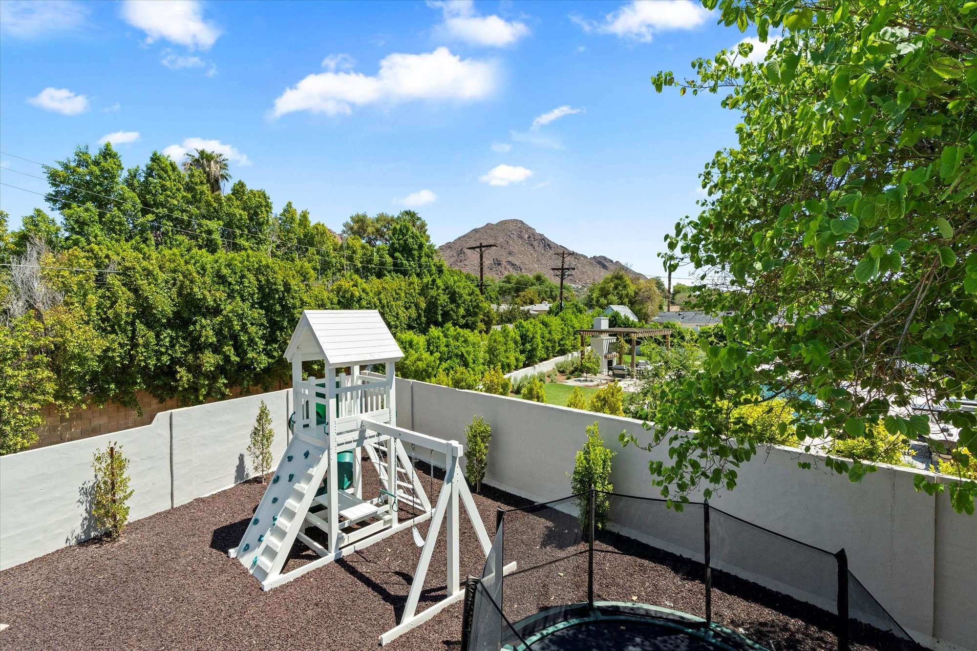 44 of 48. Well-designed outdoor play area with privacy walls, durable materials, and thoughtful placement within the backyard.