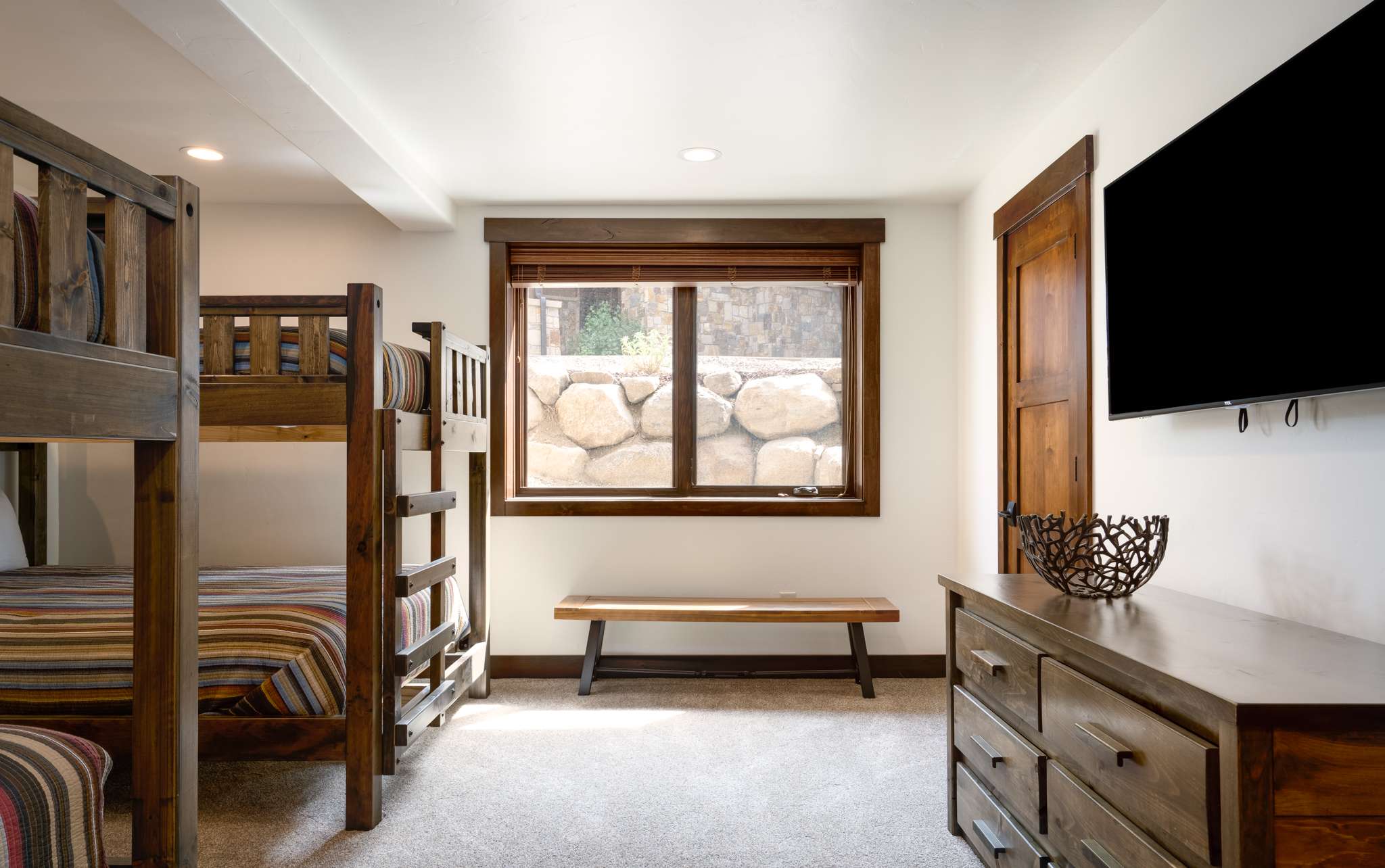 30 of 42. Bunk room with four queen beds, a TV, and a double sink en suite bath with shower/tub combo.