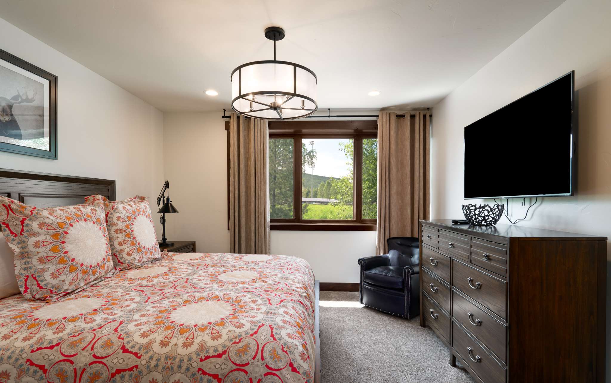 23 of 42. Lower-level spacious king bedroom with twin trundle beds, featuring modern amenities, and an en suite double sink bath with shower.