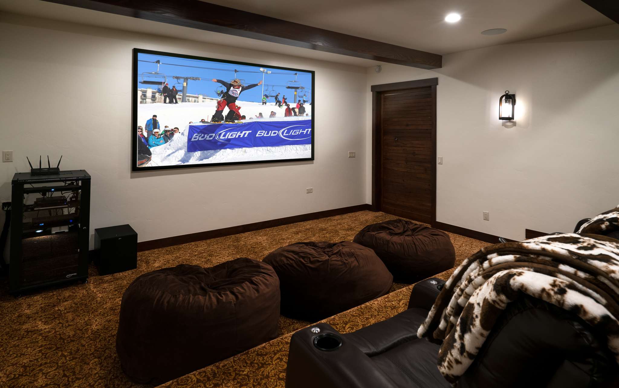 28 of 42. Enjoy cinematic experiences in this spacious home theater featuring oversized seating and modern audio-visual equipment.