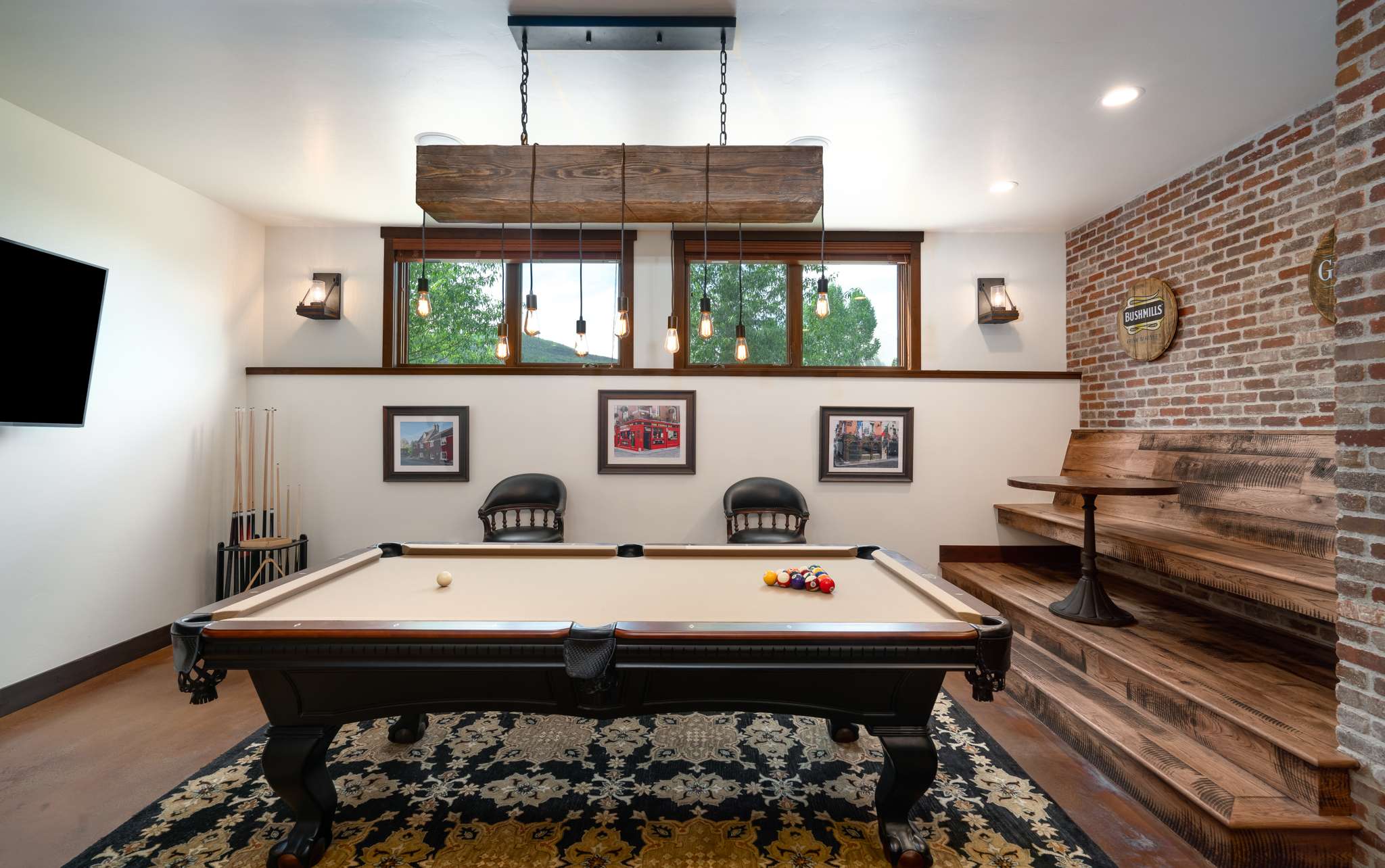 25 of 42. Spacious game room features a billiard table, TVs, game console, and a custom bar with multiple tables and seating options.