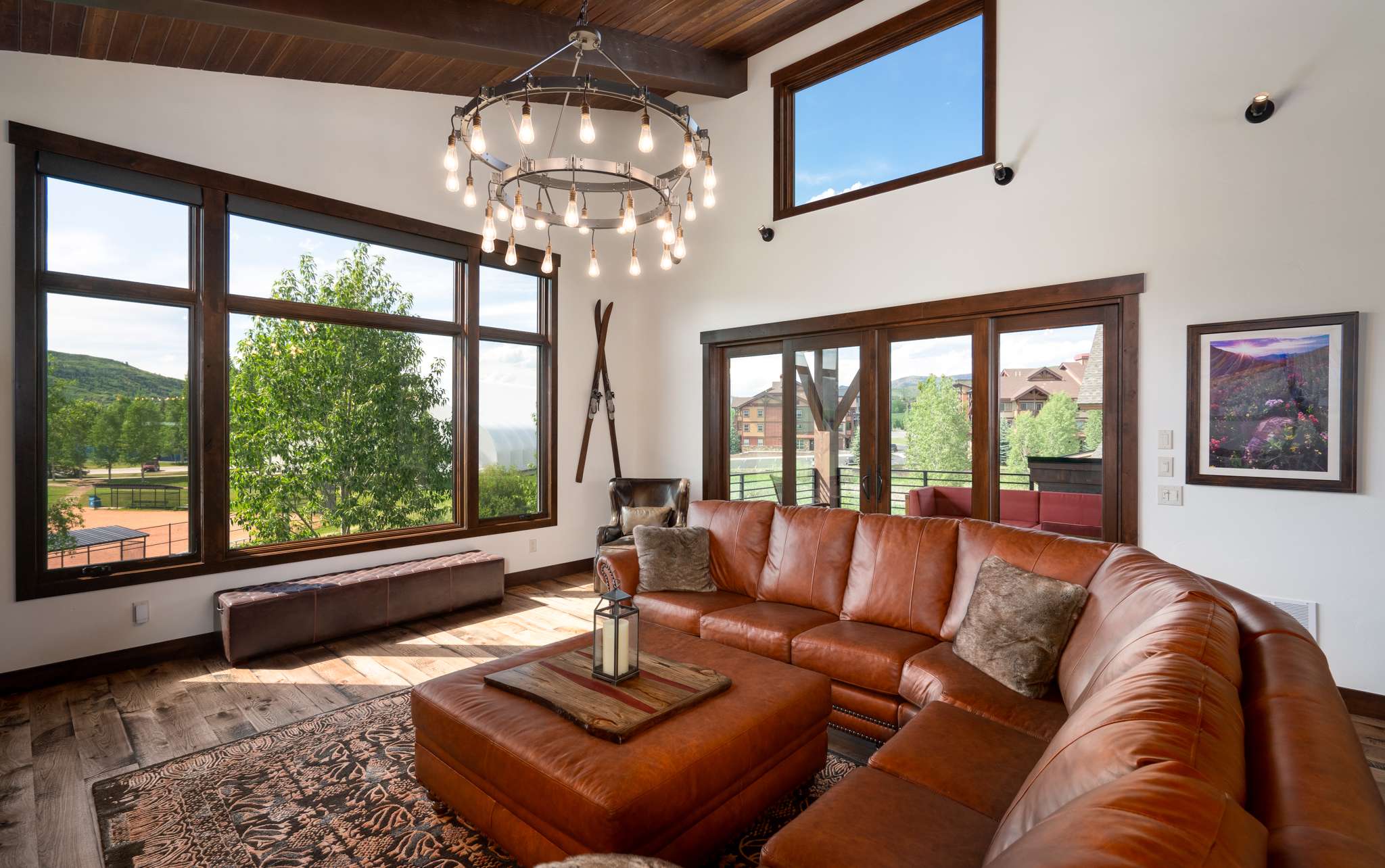 7 of 42. Spacious living area features large windows that showcase beautiful mountain views, offering an inviting atmosphere.