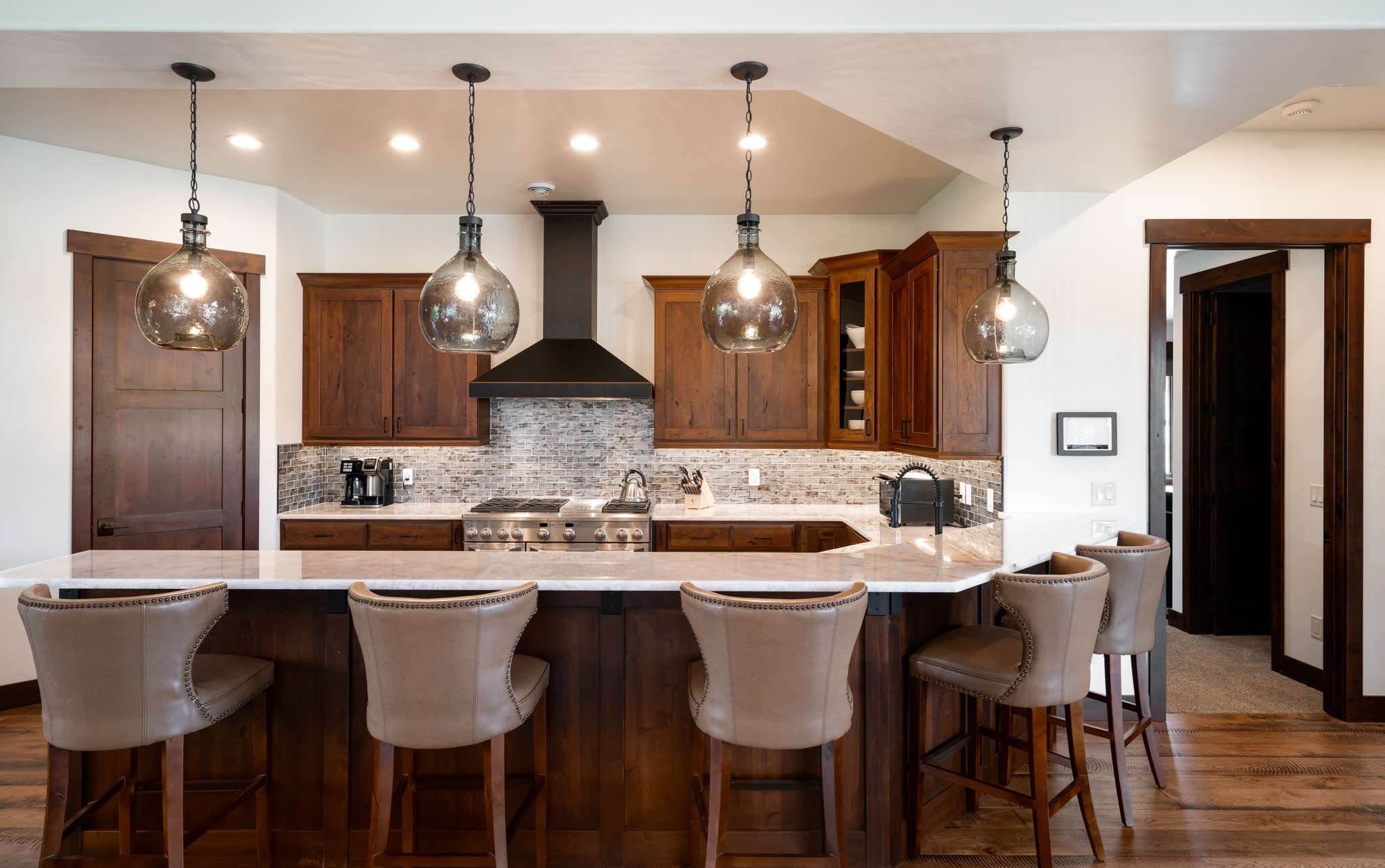 12 of 42. Modern kitchen featuring rich wood cabinetry, sleek countertops, and a spacious island perfect for gatherings.
