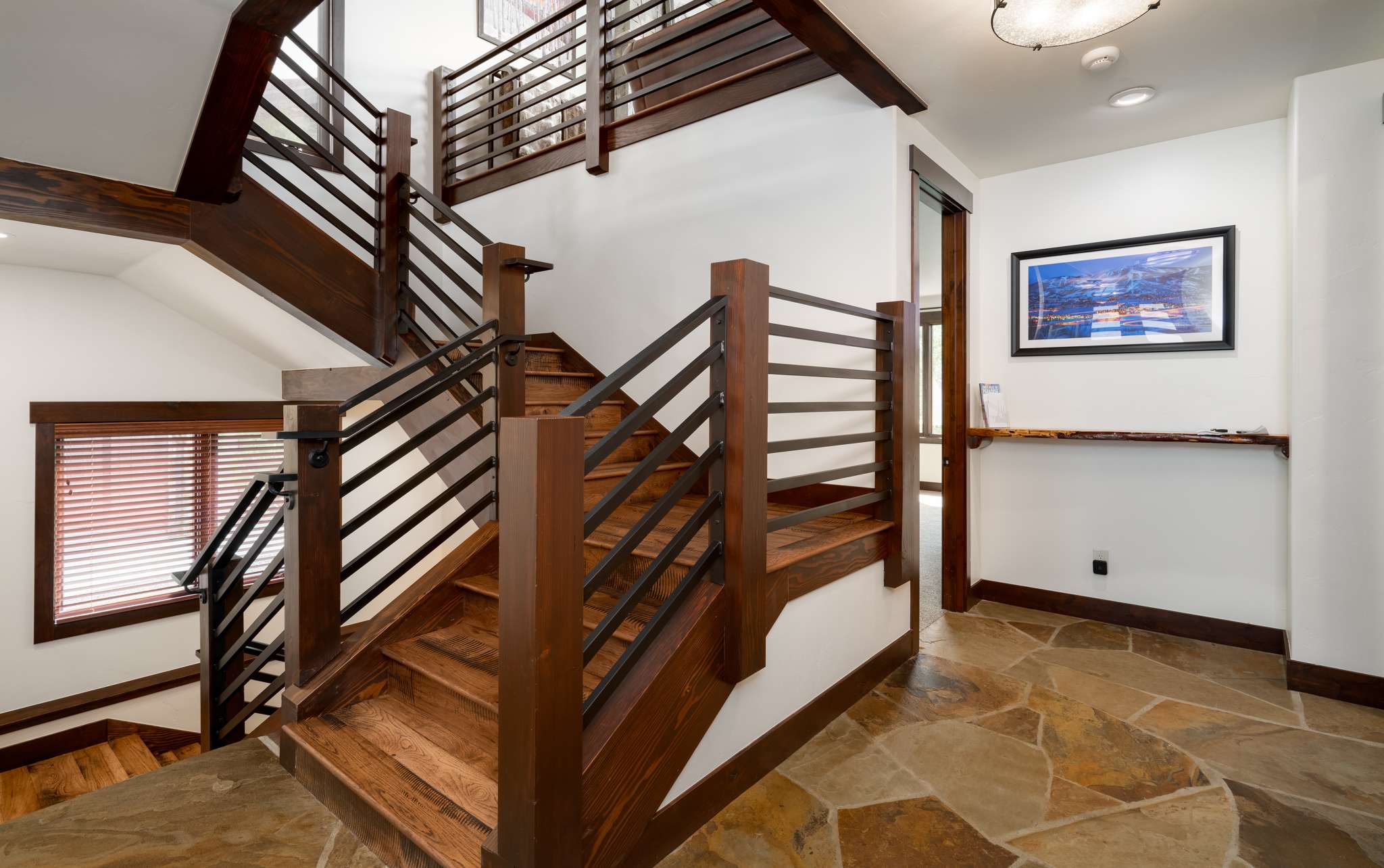 22 of 42. Inviting entryway featuring a blend of natural stone and warm wood accents, leading to multiple living spaces.