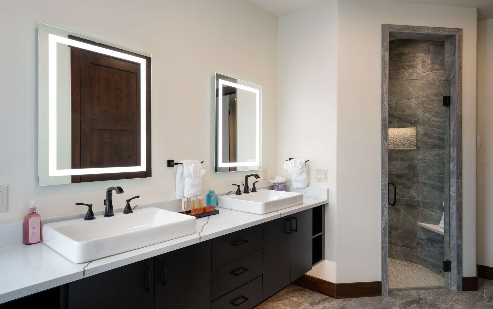 18 of 42. Modern bathroom featuring dual sinks, sleek fixtures, and a spacious walk-in shower for optimal convenience.