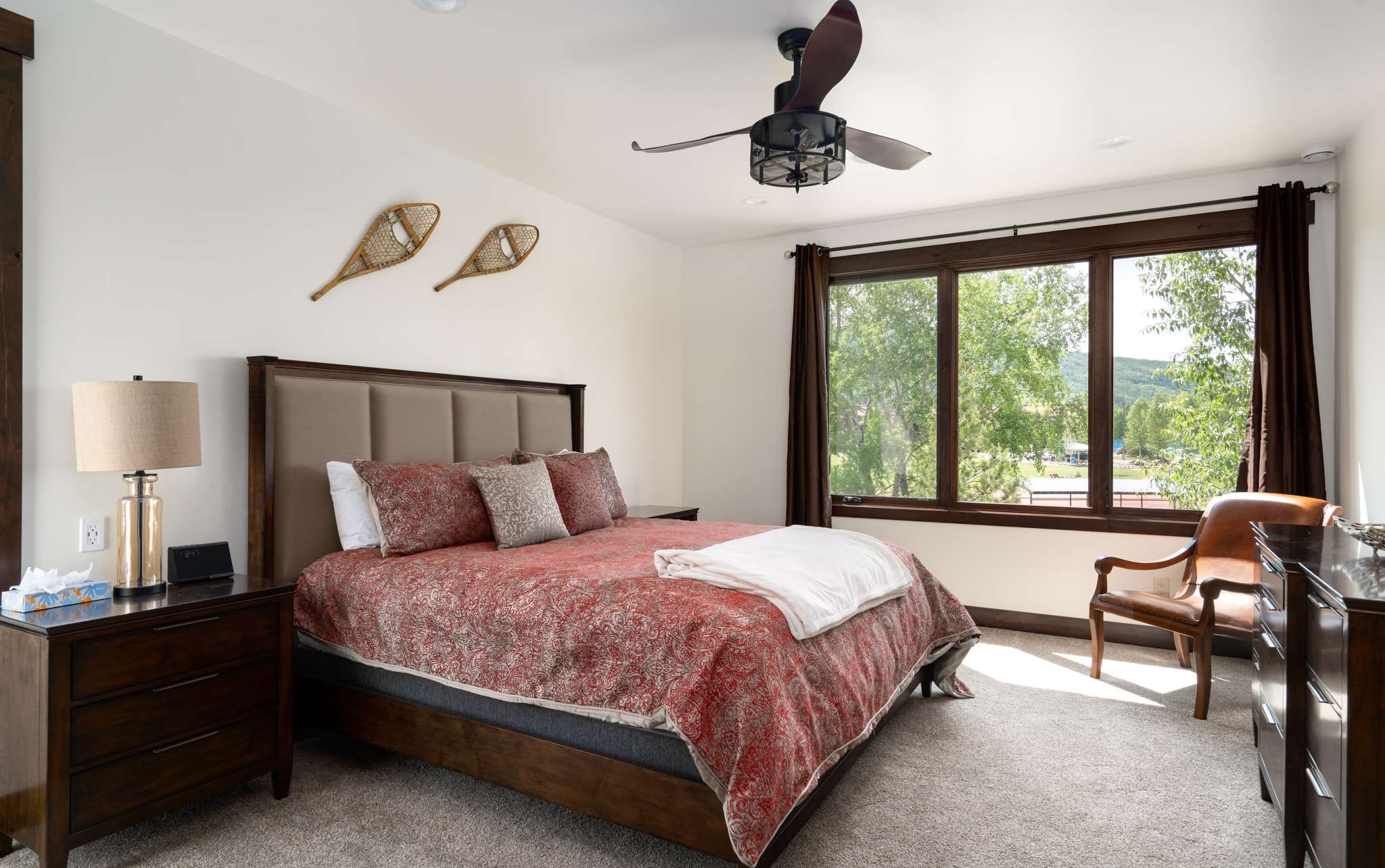20 of 42. King bedroom featuring a ceiling fan, large windows with mountain views, an en-suite double sink bath with steam shower and private toilet room.