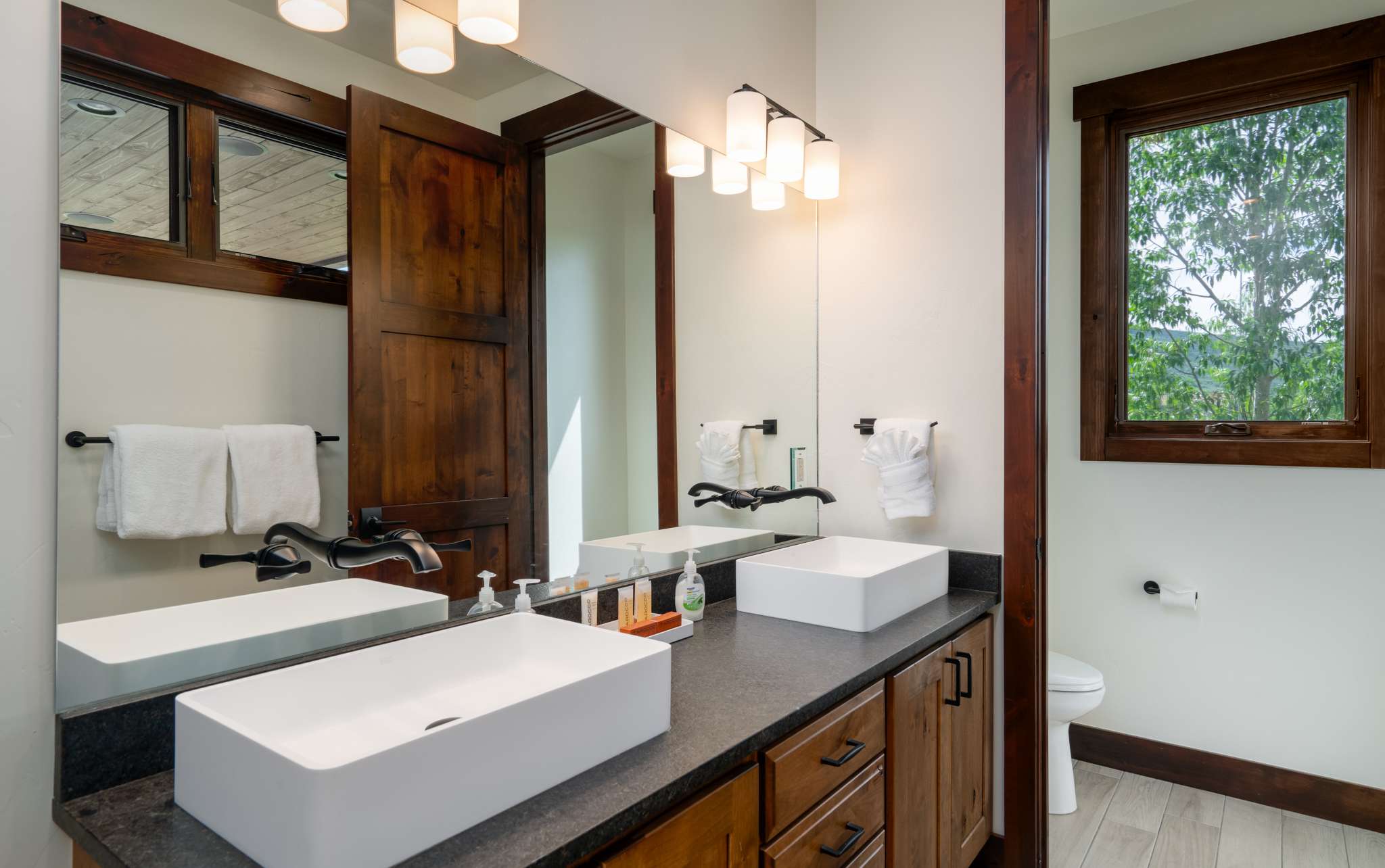 21 of 42. Modern bathroom featuring dual sinks, ample natural light, and a thoughtfully designed layout for convenience.