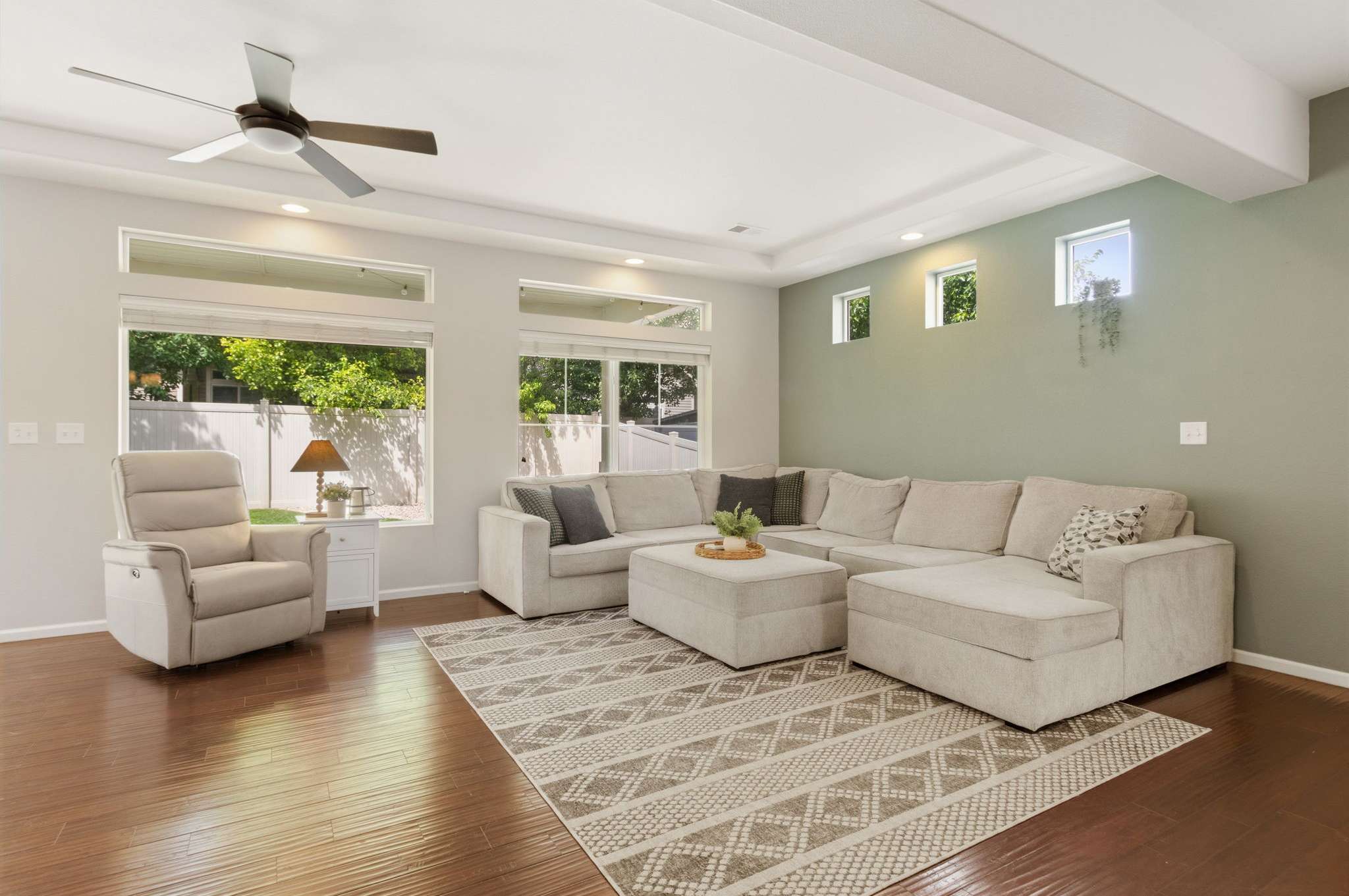8 of 34. A spacious living room is accentuated by large windows, creating an atmosphere that feels both open and cozy.