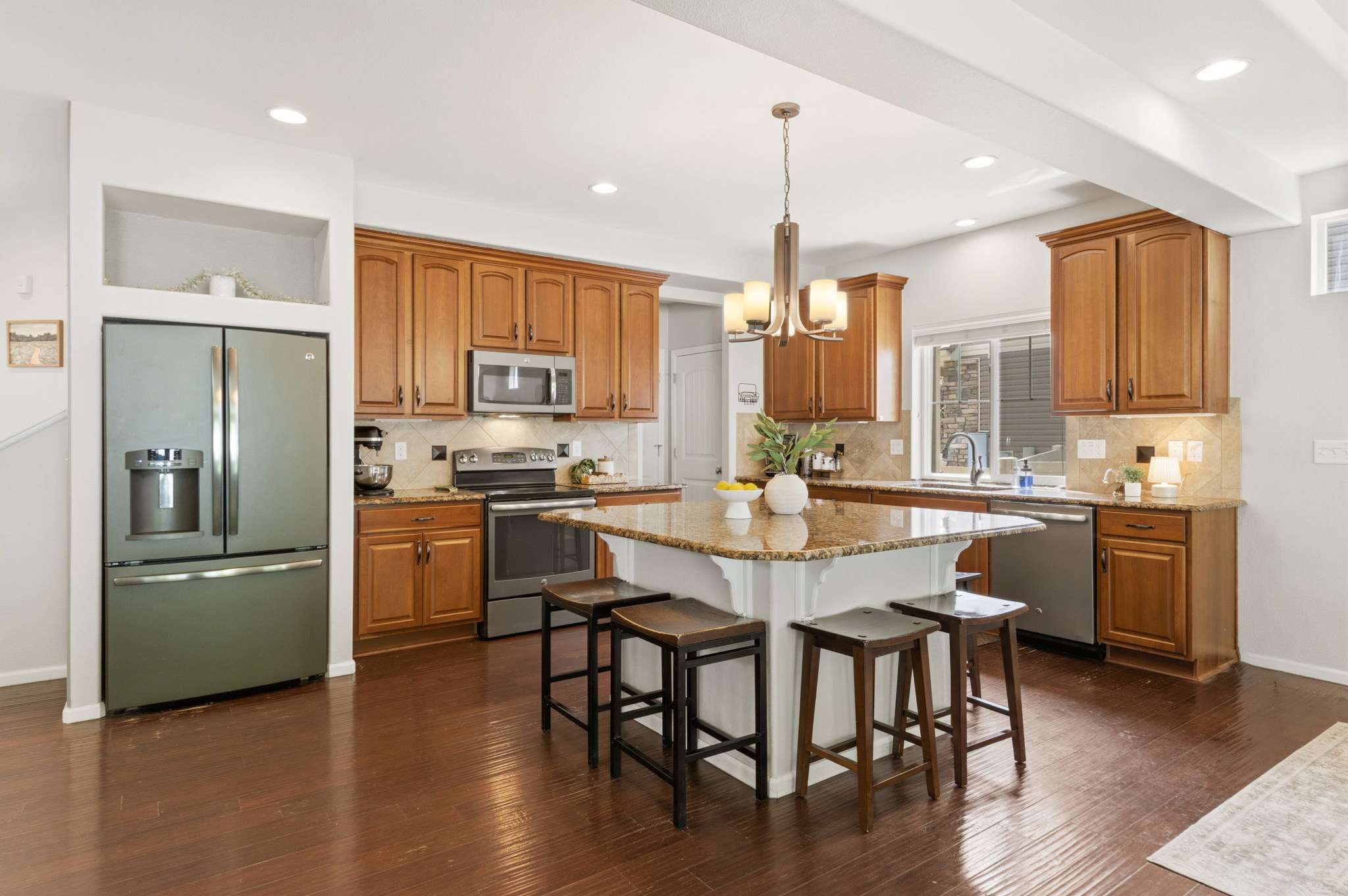 11 of 34. A warm and welcoming kitchen with granite countertops, storage, and an oversized island presents a space that is perfect for slow weekend mornings and chats after dinner.