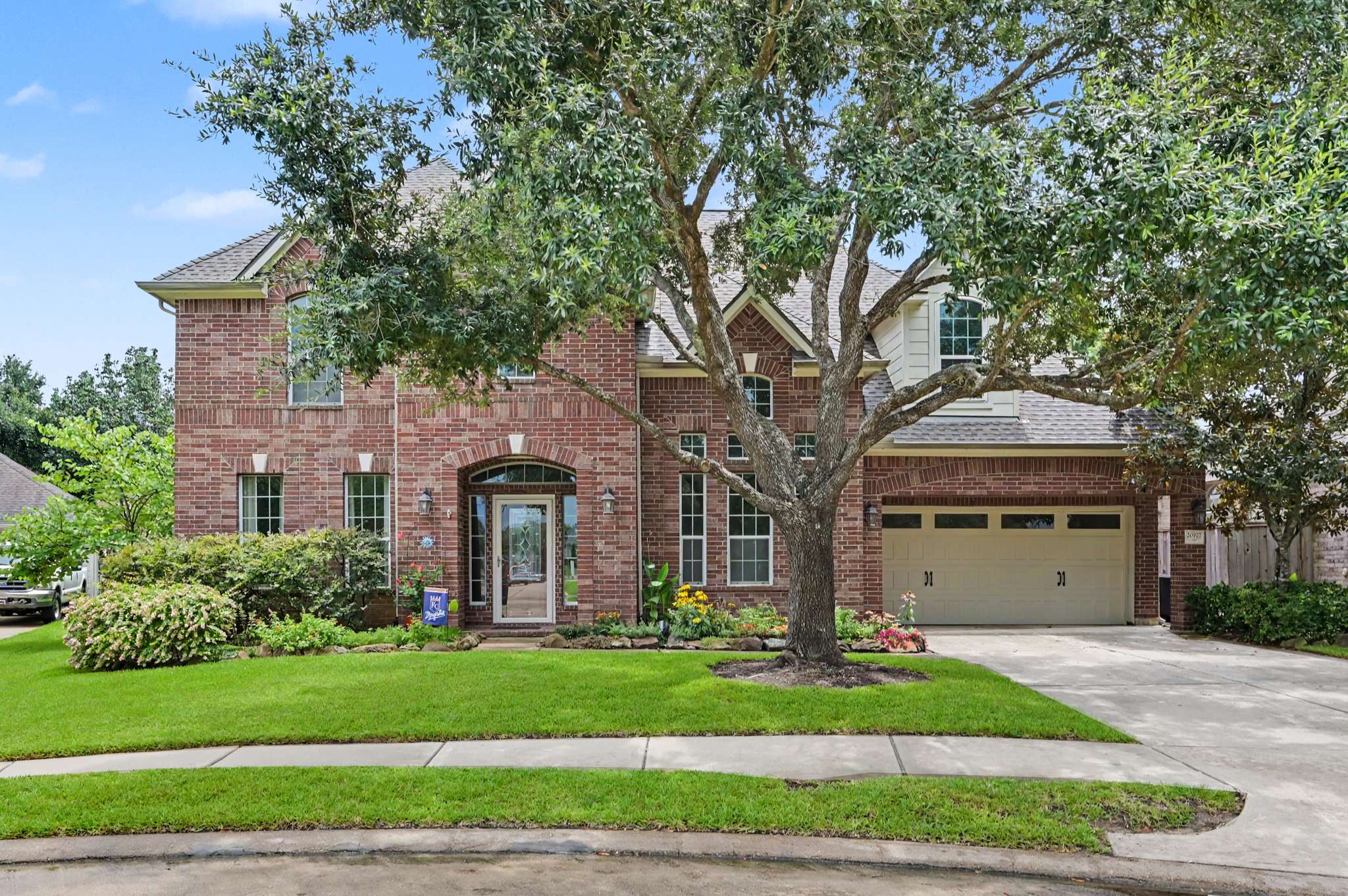 15 of 71. Stunning brick home featuring lush landscaping, spacious driveway, and ample outdoor space for entertainment.
